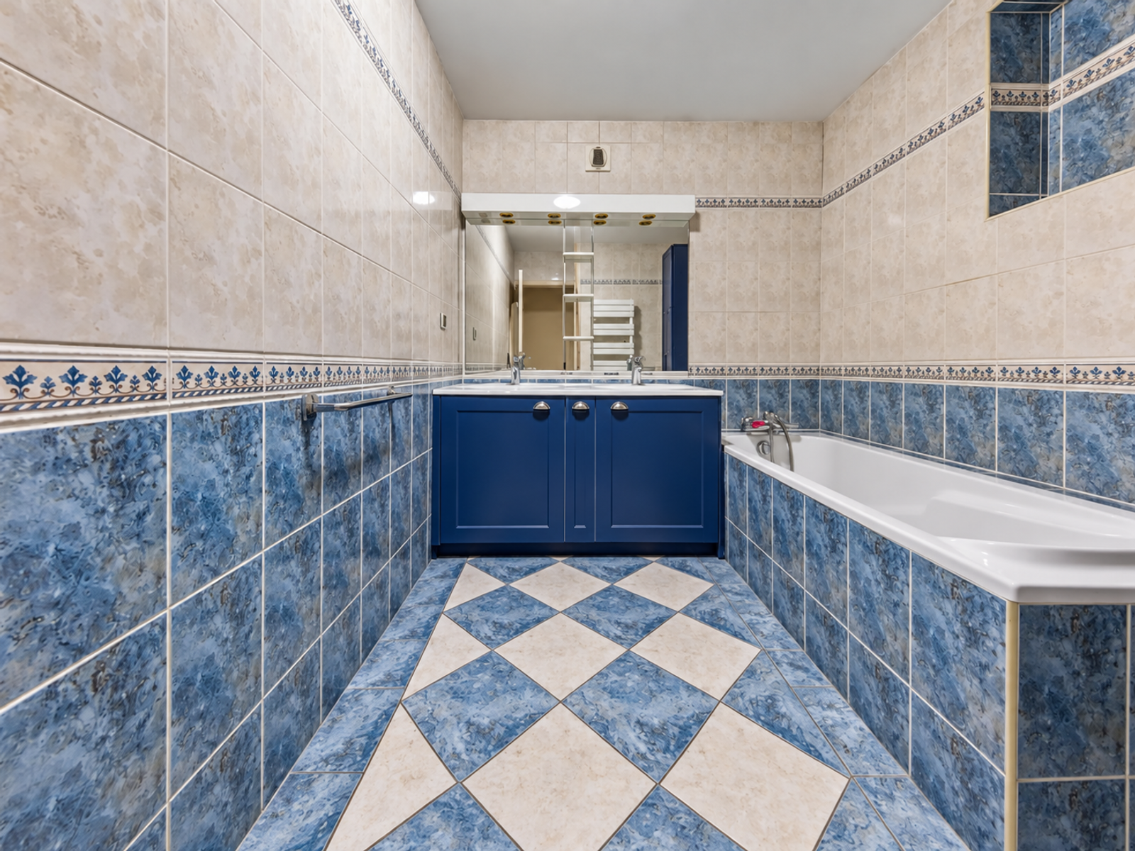 Salle de bains avec baignoire et carrelage bleu