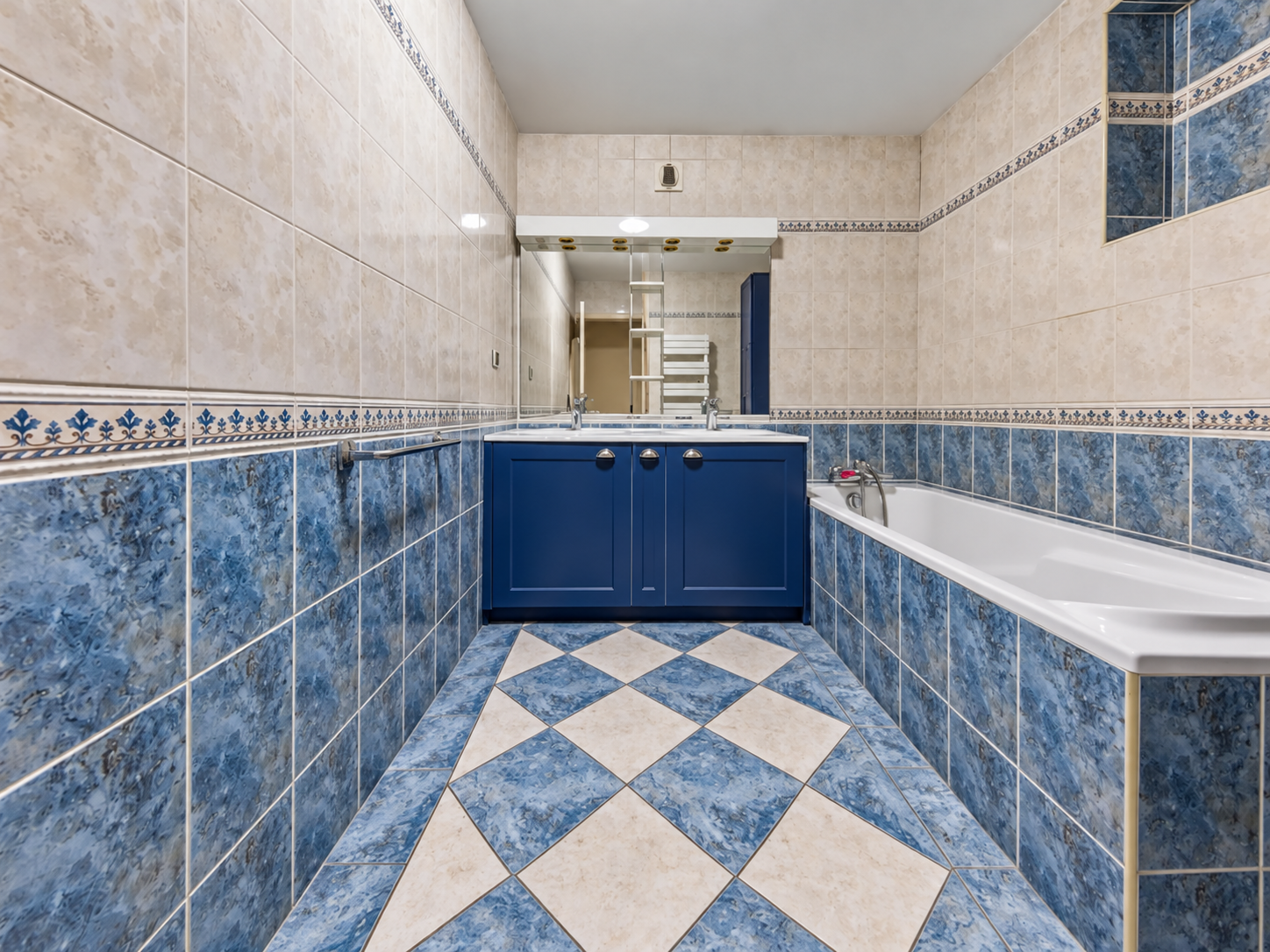 Salle de bains avec baignoire et carrelage bleu