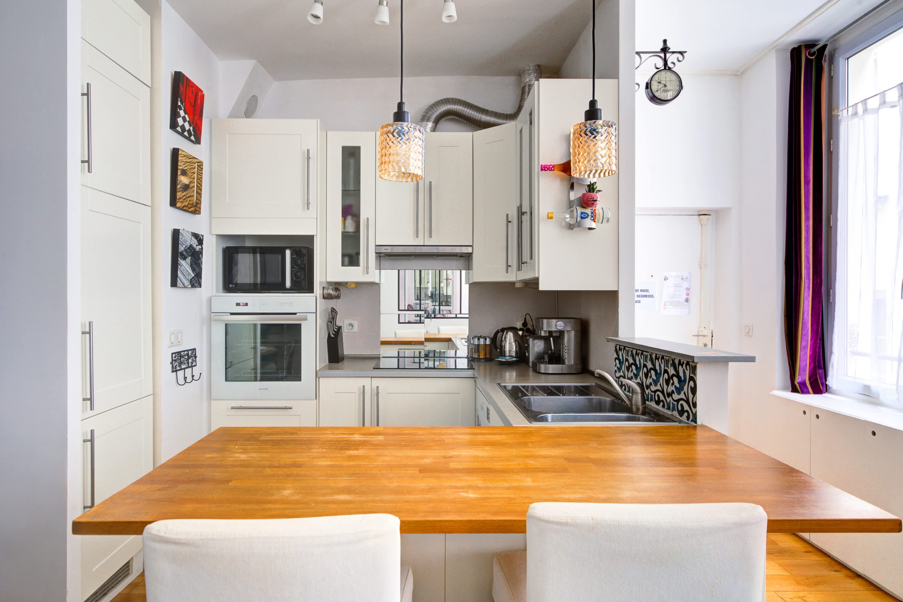 Functional fully equipped kitchen with a bar and two high stools