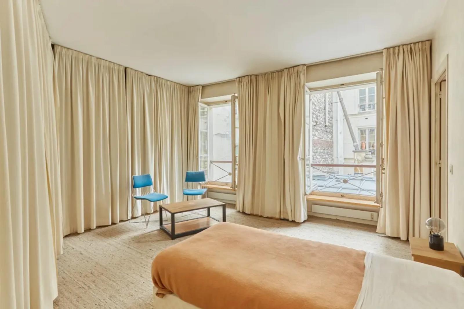 Chambre lumineuse avec deux fenêtres et rideaux