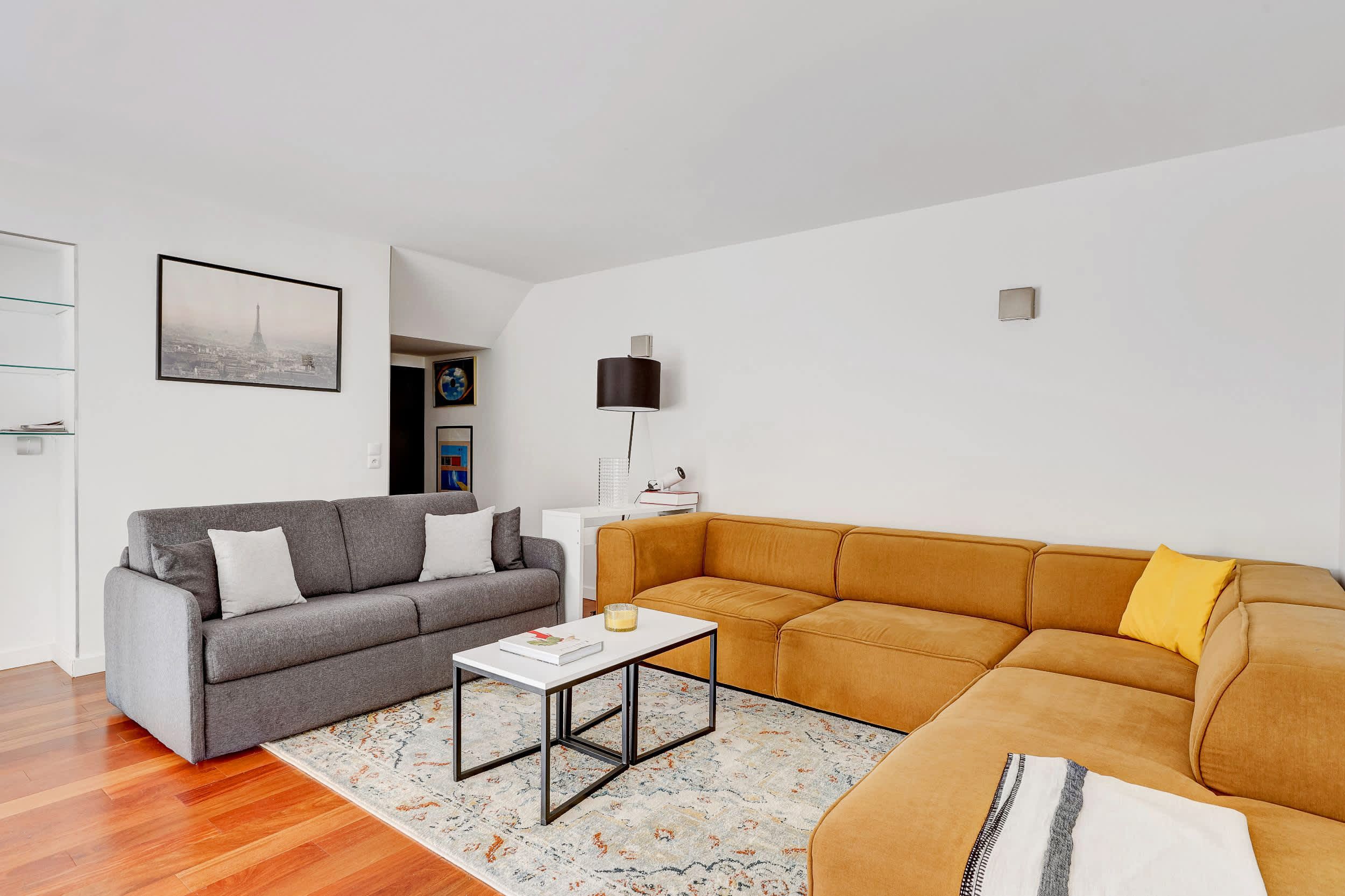 Bright architect-designed Paris apartment with a glass roof, modern open living space, sofa, and open kitchen.