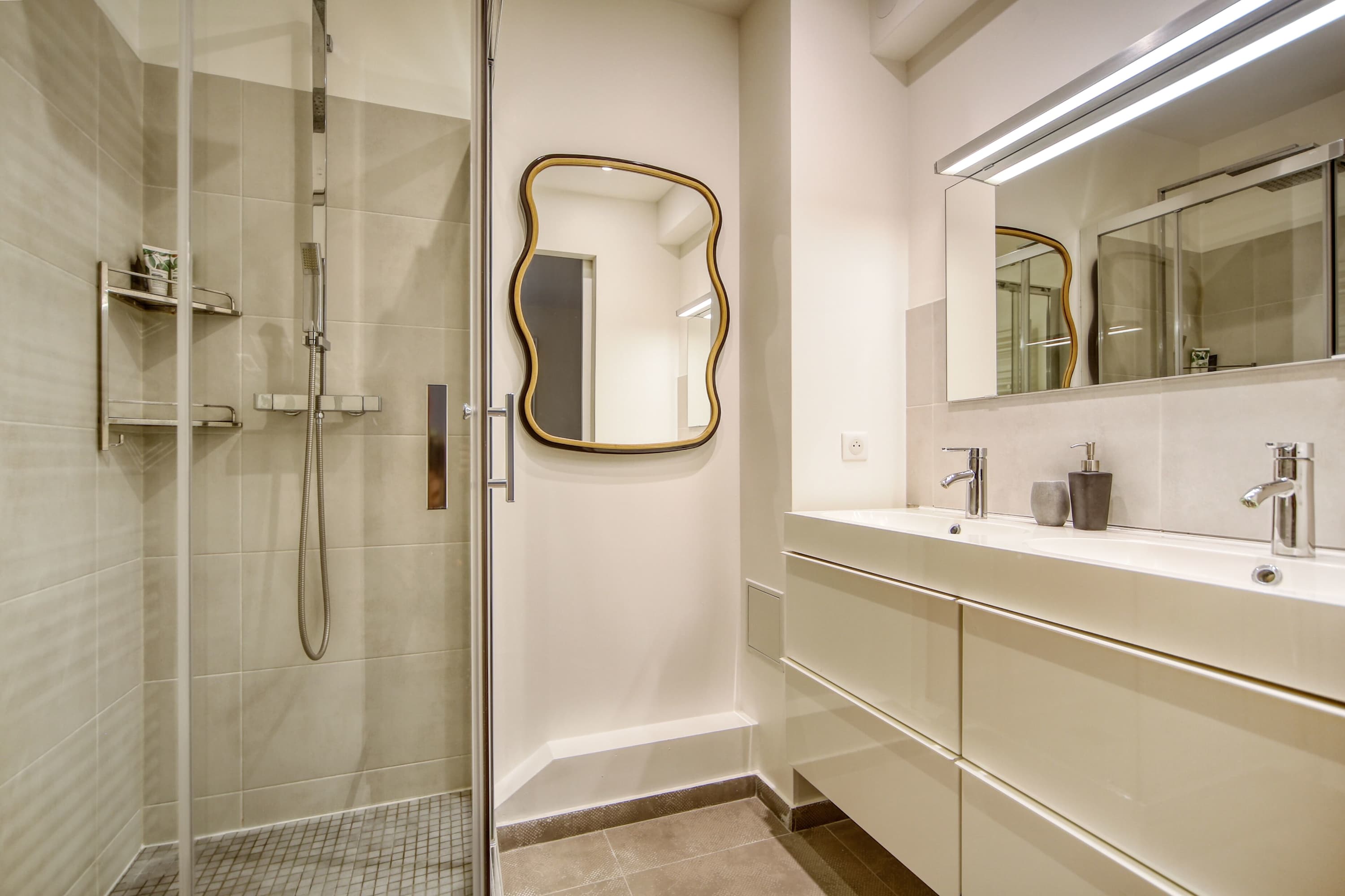Deuxième salle de bain équipée avec lavabo et douche