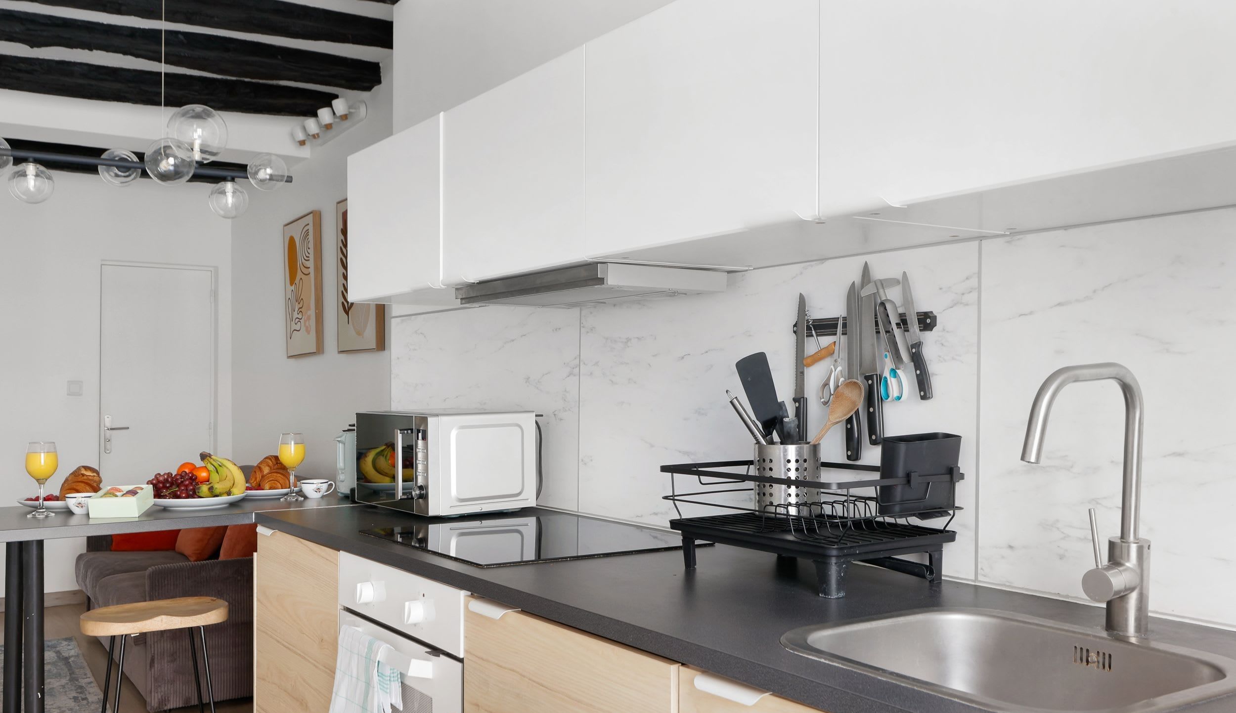 Appartement meublé rue Saint-Séverin Paris 5e, canapé-lit sous des poutres apparentes dans un intérieur du Quartier Latin