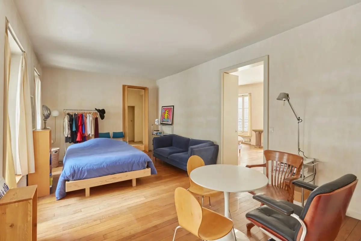 Chambre lumineuse avec canapé et coin repas