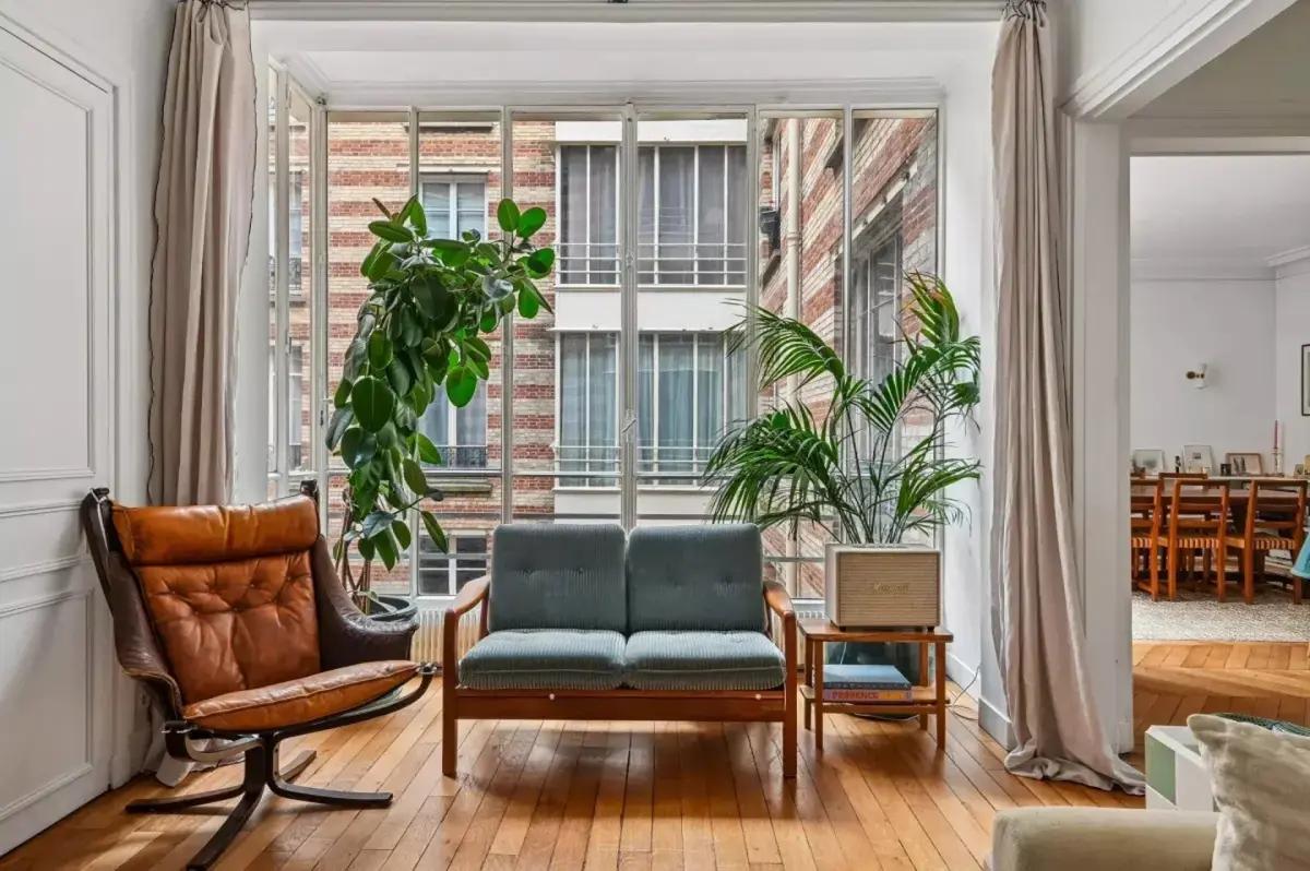 Coin détente dans le bow-window avec fauteuil et plantes