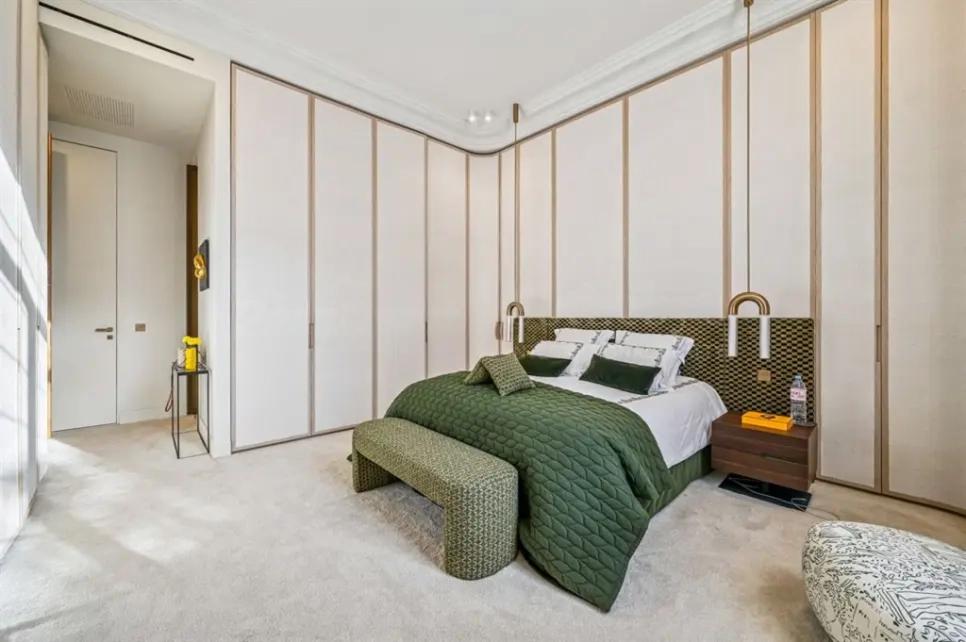 Chambre de luxe avec literie verte et rangements