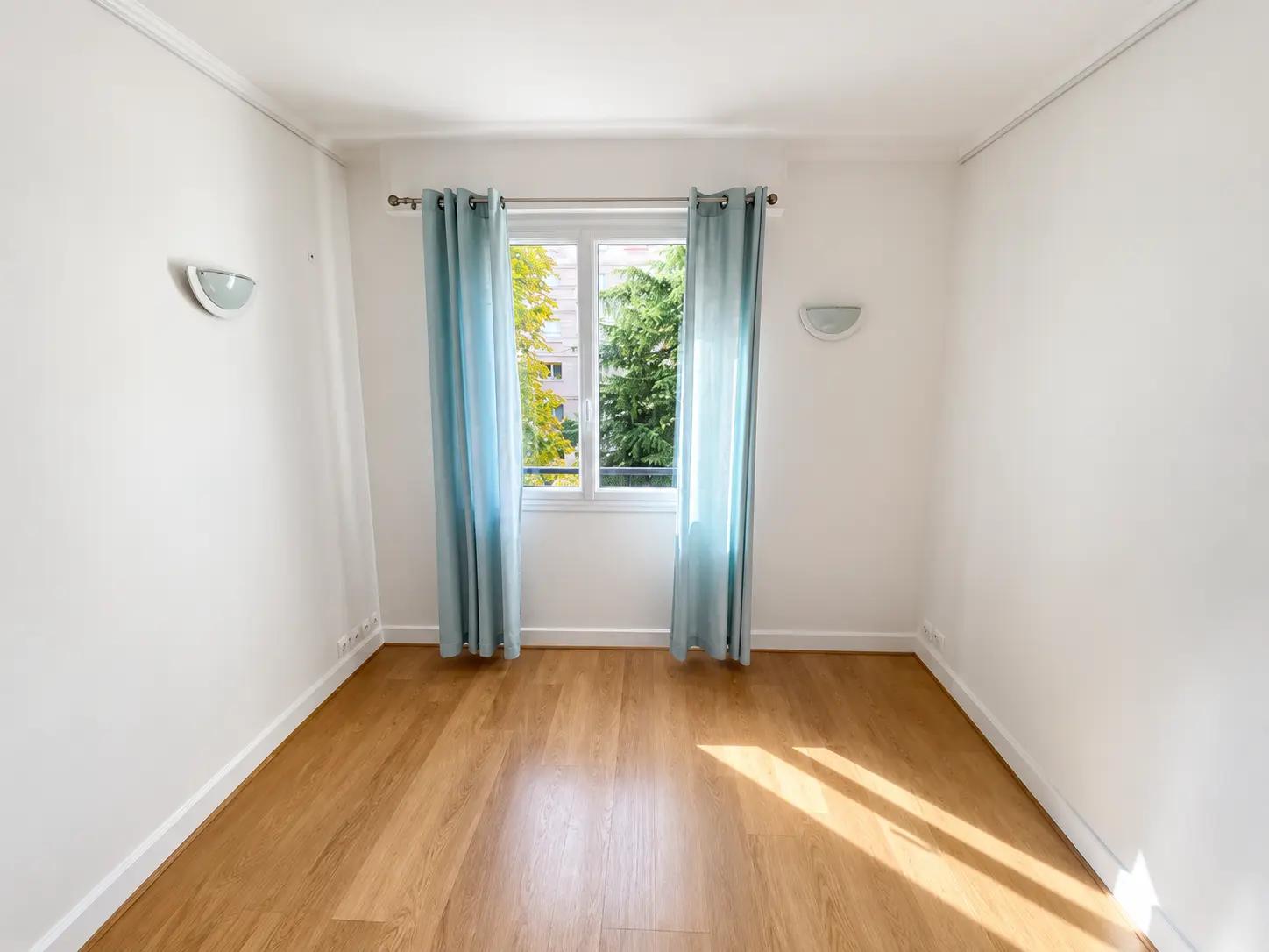 Bright bedroom with wooden floors and garden-facing window