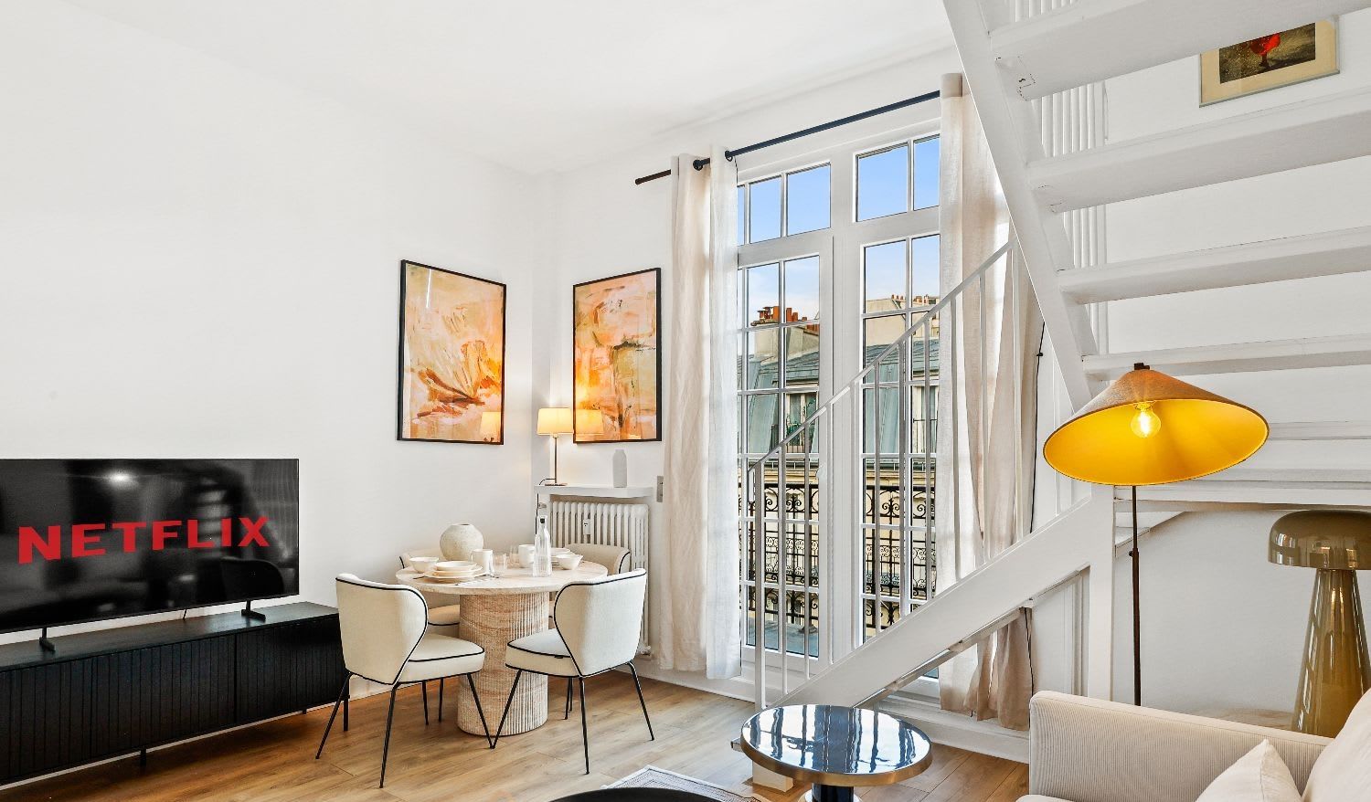 Duplex de luxe Paris 16e, séjour double hauteur avec balcon en fer forgé et vue Tour Eiffel, location meublée moyenne durée
