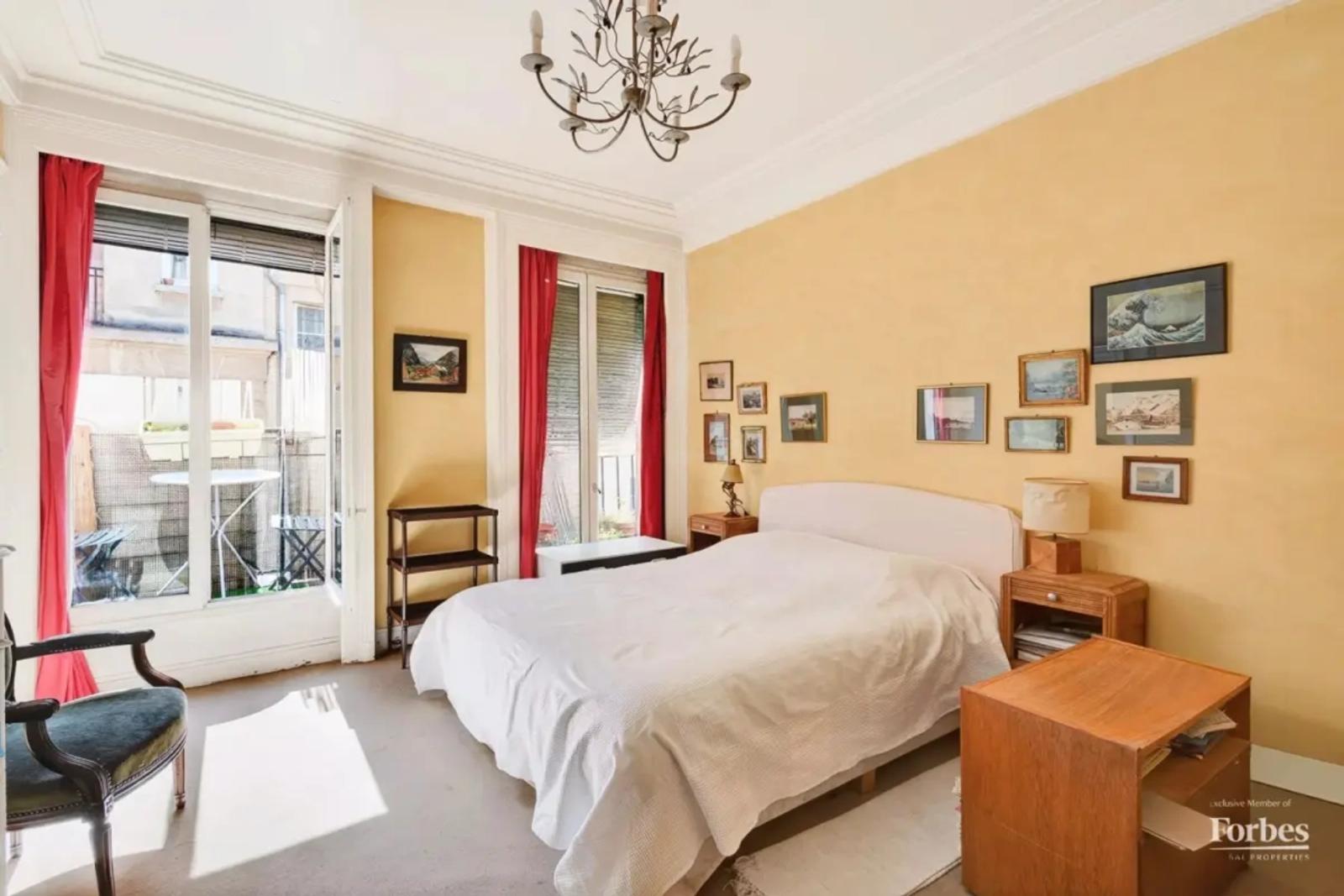 Chambre lumineuse avec balcon et rideaux rouges