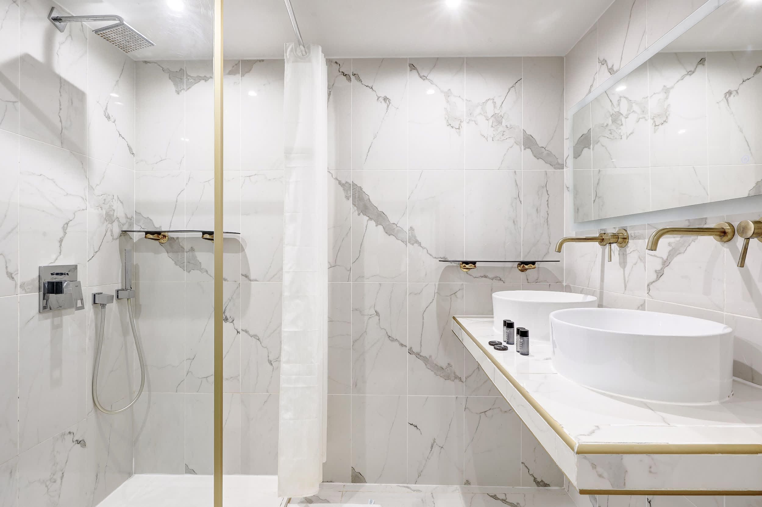 Bathroom: shower, double sinks, mirror, and toilet.