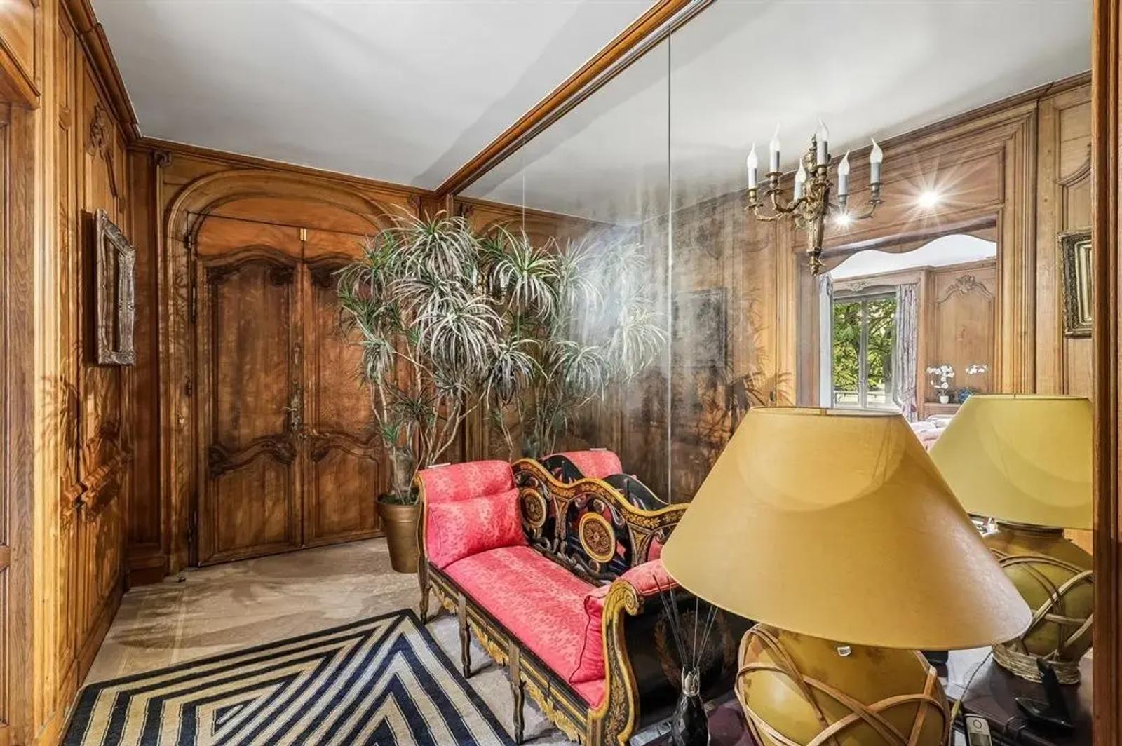 Entrée boisée avec mur de miroirs et banquette rouge