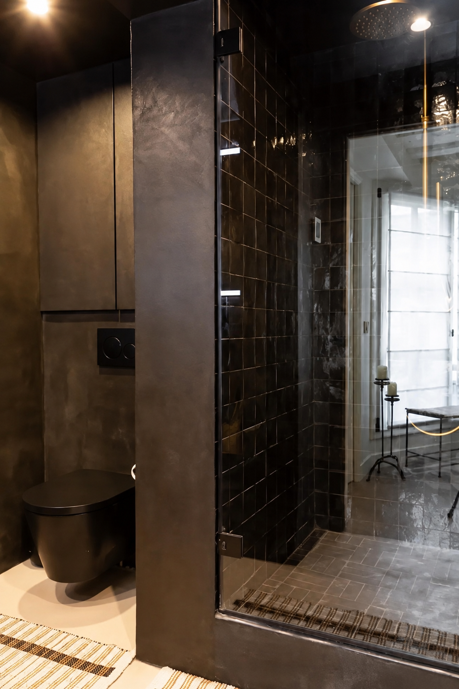 Salle d'eau moderne avec douche vitrée et carrelage noir