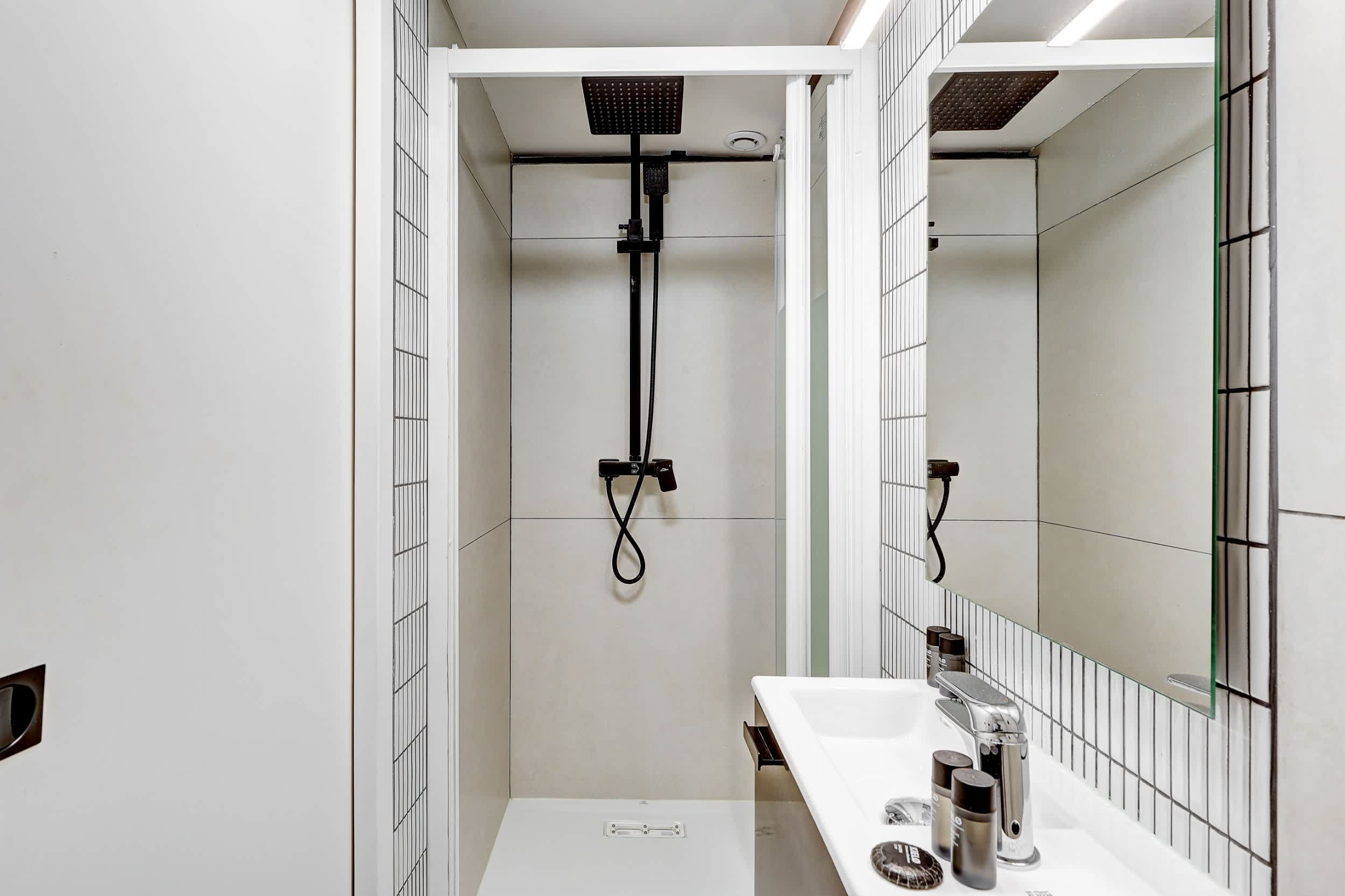 Salle de bain : douche, lavabo, miroir et toilette