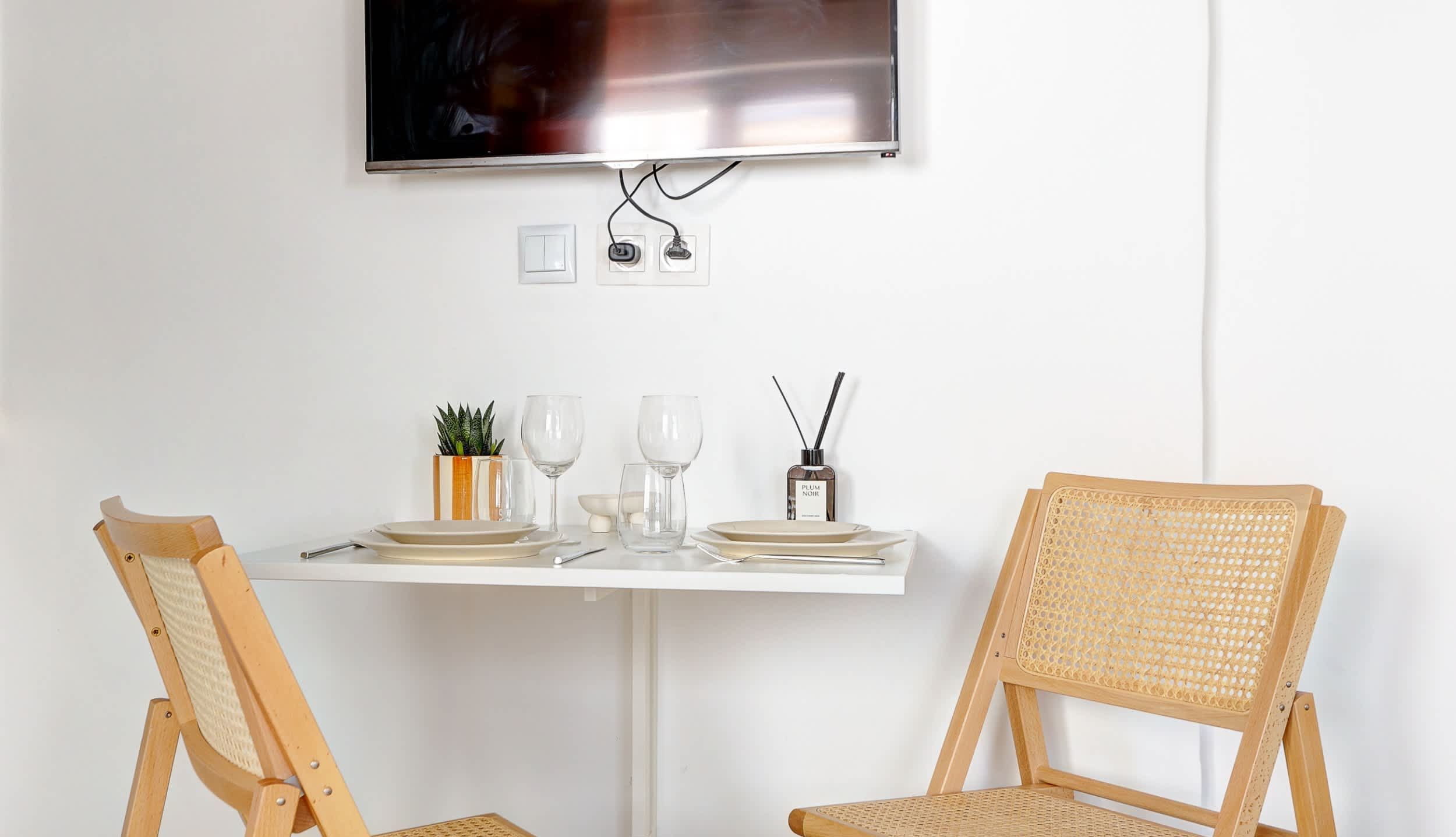 Welcome to our living room, open onto the kitchen, featuring a comfortable sofa bed, a dining corner and a TV.