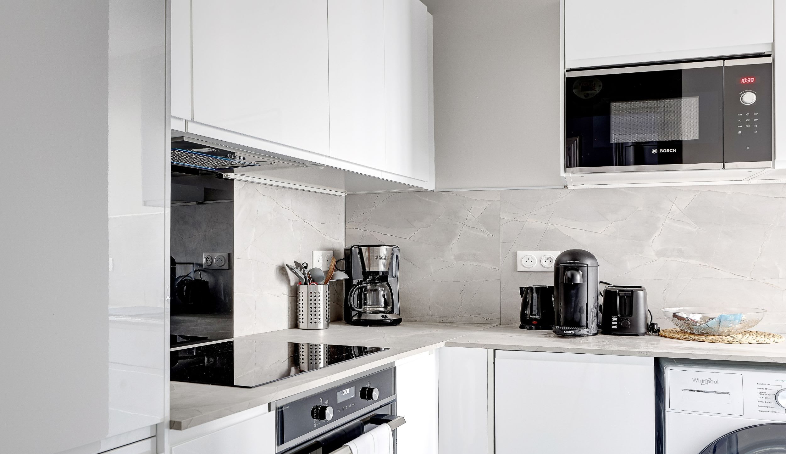 This bright, fully equipped kitchen has everything you need for a pleasant stay, including a toaster, microwave, stovetop, kettle, and even a washing machine for your convenience.