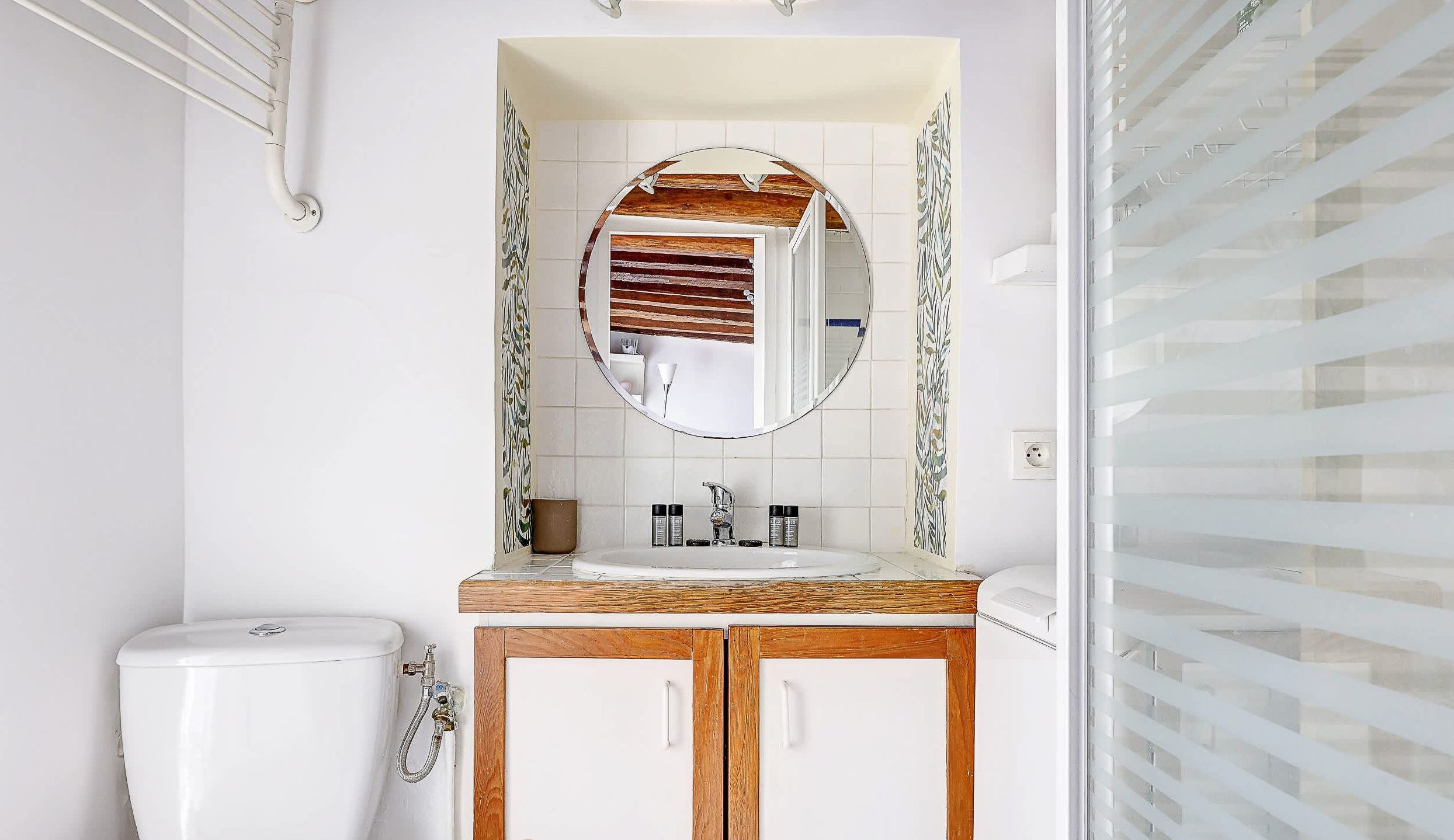 Bathroom: shower, washing machine, sink, mirror, storage, and toilet.
