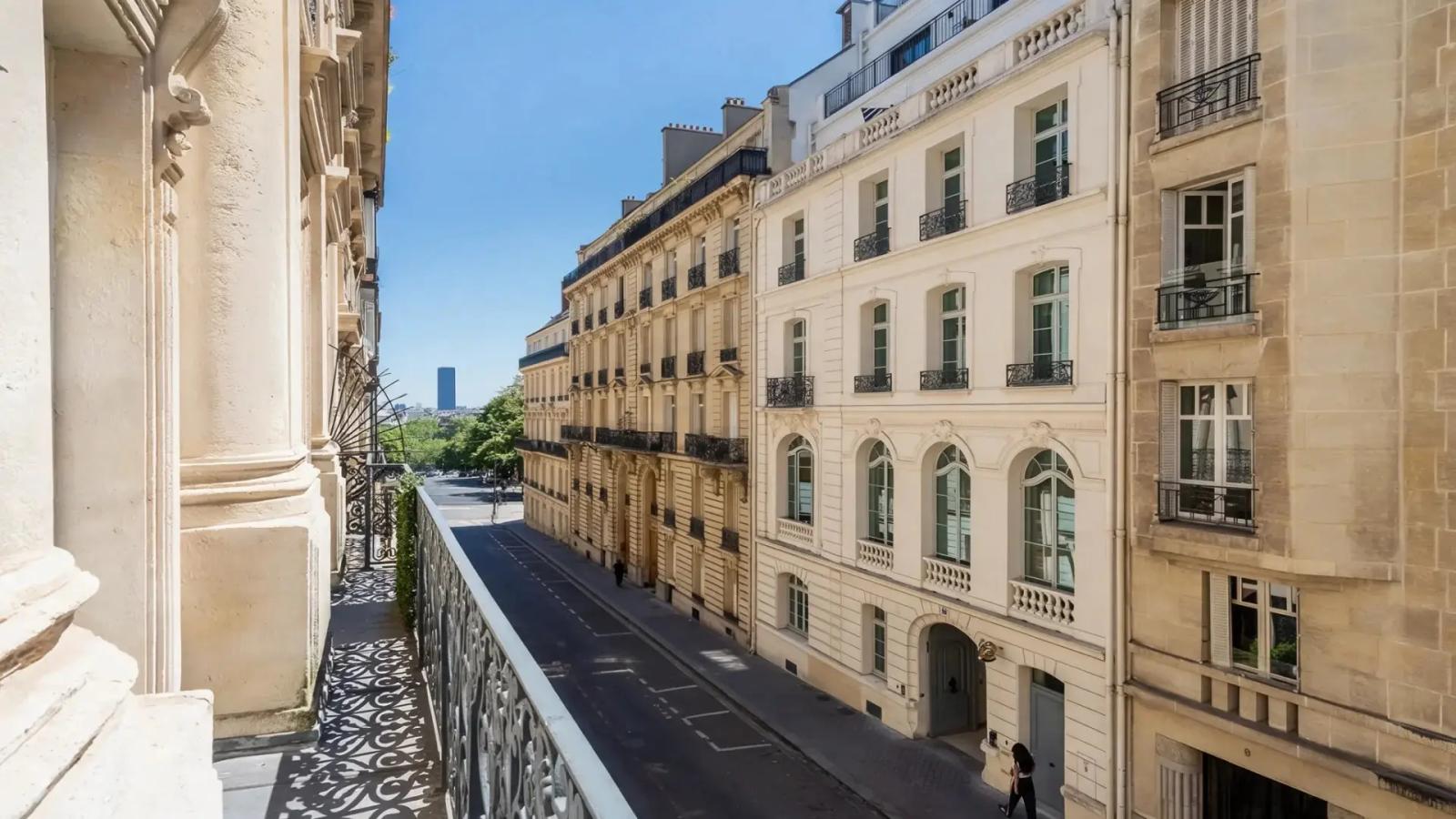 Balcon donnant sur une rue bordée d’immeubles en pierre