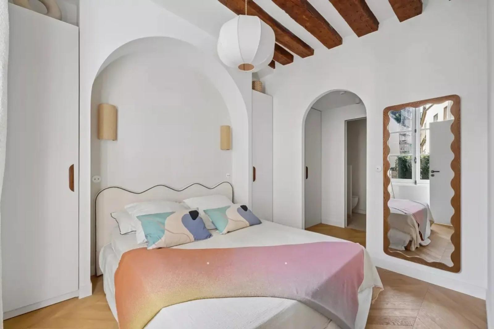 Chambre rénovée avec poutres et porte en arche