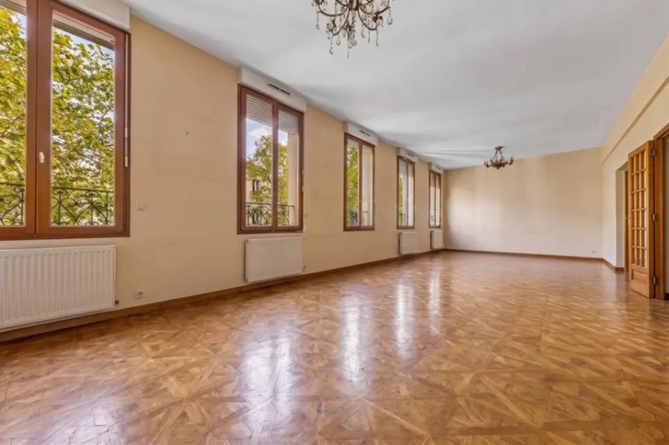Grand séjour avec parquet et hautes fenêtres