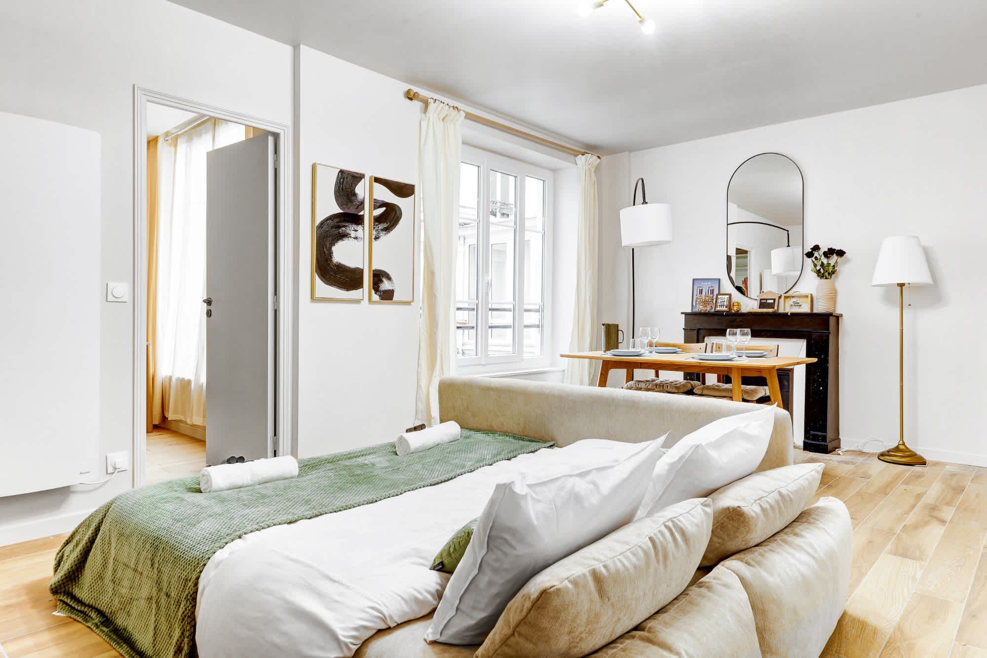 Appartement meublé rénové de 55 m² rue des Tournelles Paris 4e, canapé-lit et coin repas dans un intérieur lumineux du Marais