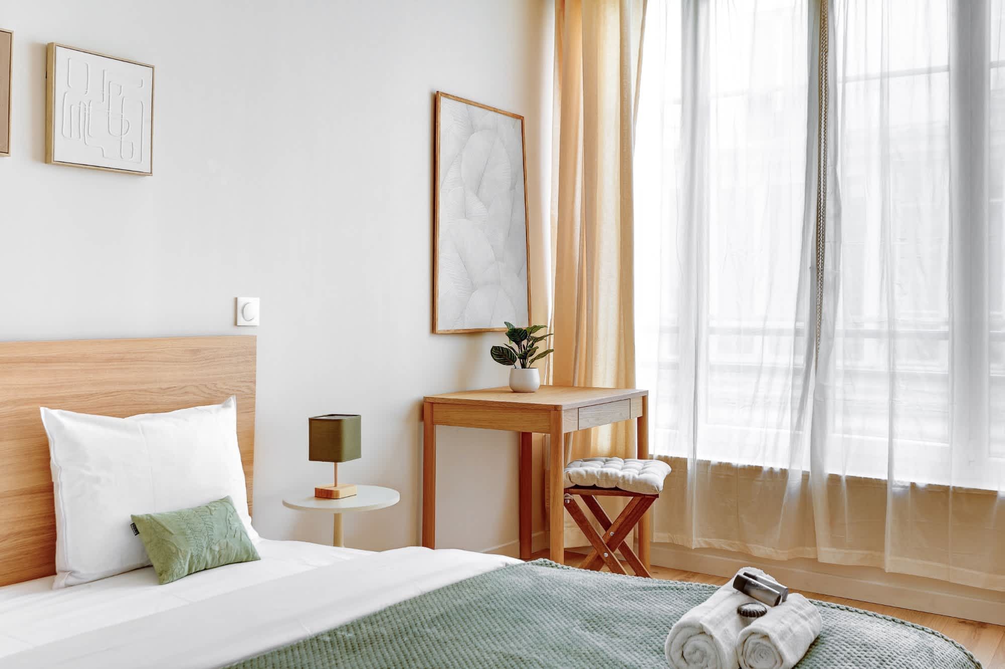 Appartement meublé rénové de 55 m² rue des Tournelles Paris 4e, canapé-lit et coin repas dans un intérieur lumineux du Marais
