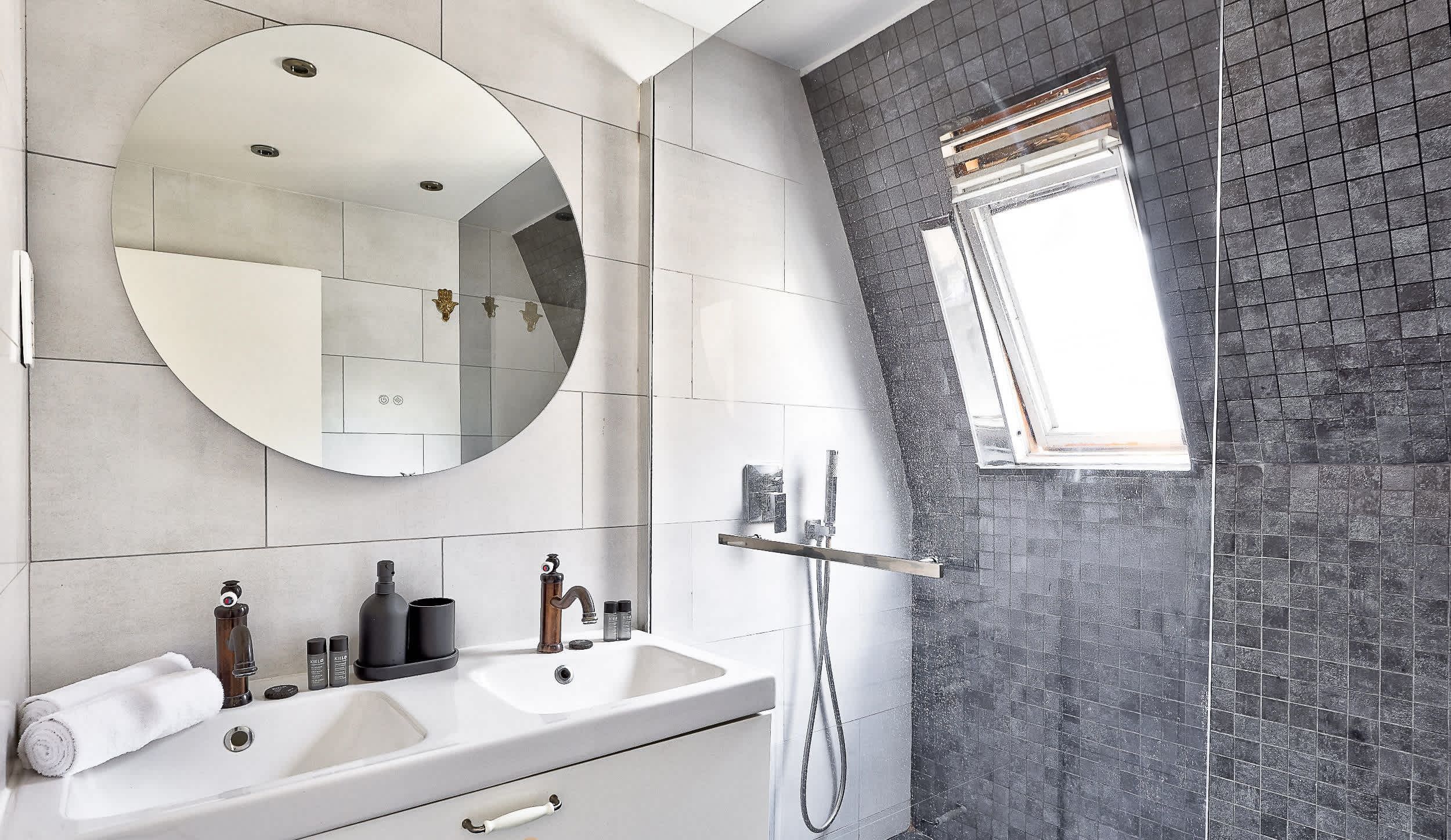 Salle de bain : douche, lavabos, miroir et toilette