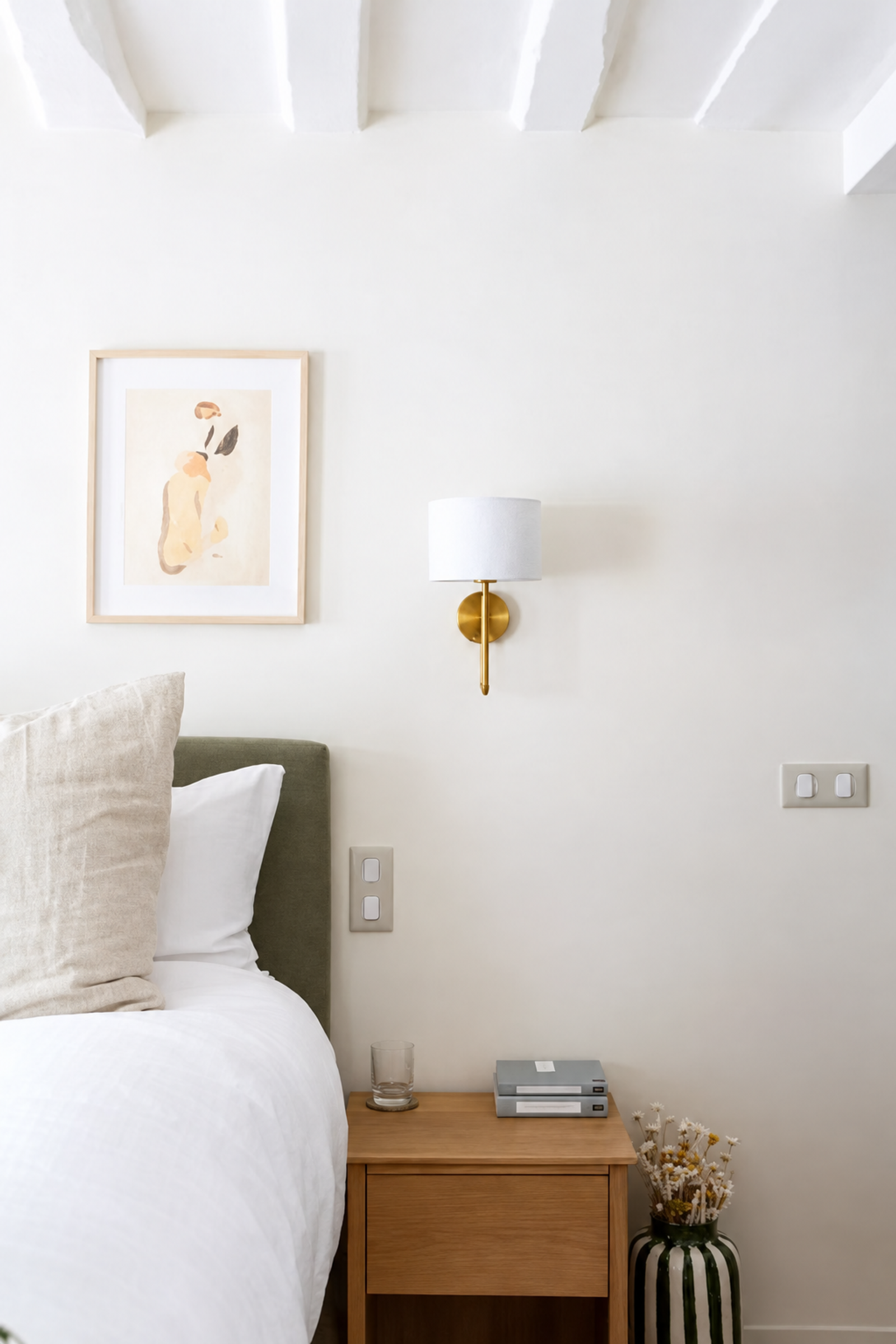 Chambre lumineuse avec poutres et table de chevet