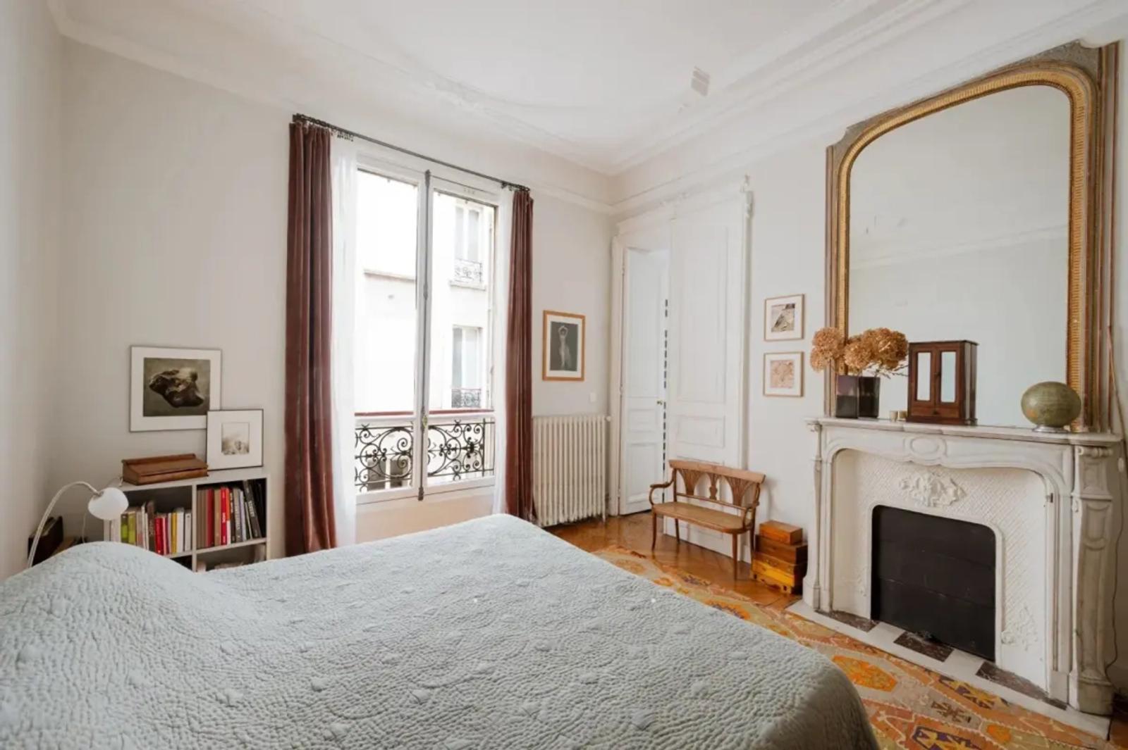 Chambre lumineuse avec cheminée ancienne et parquet