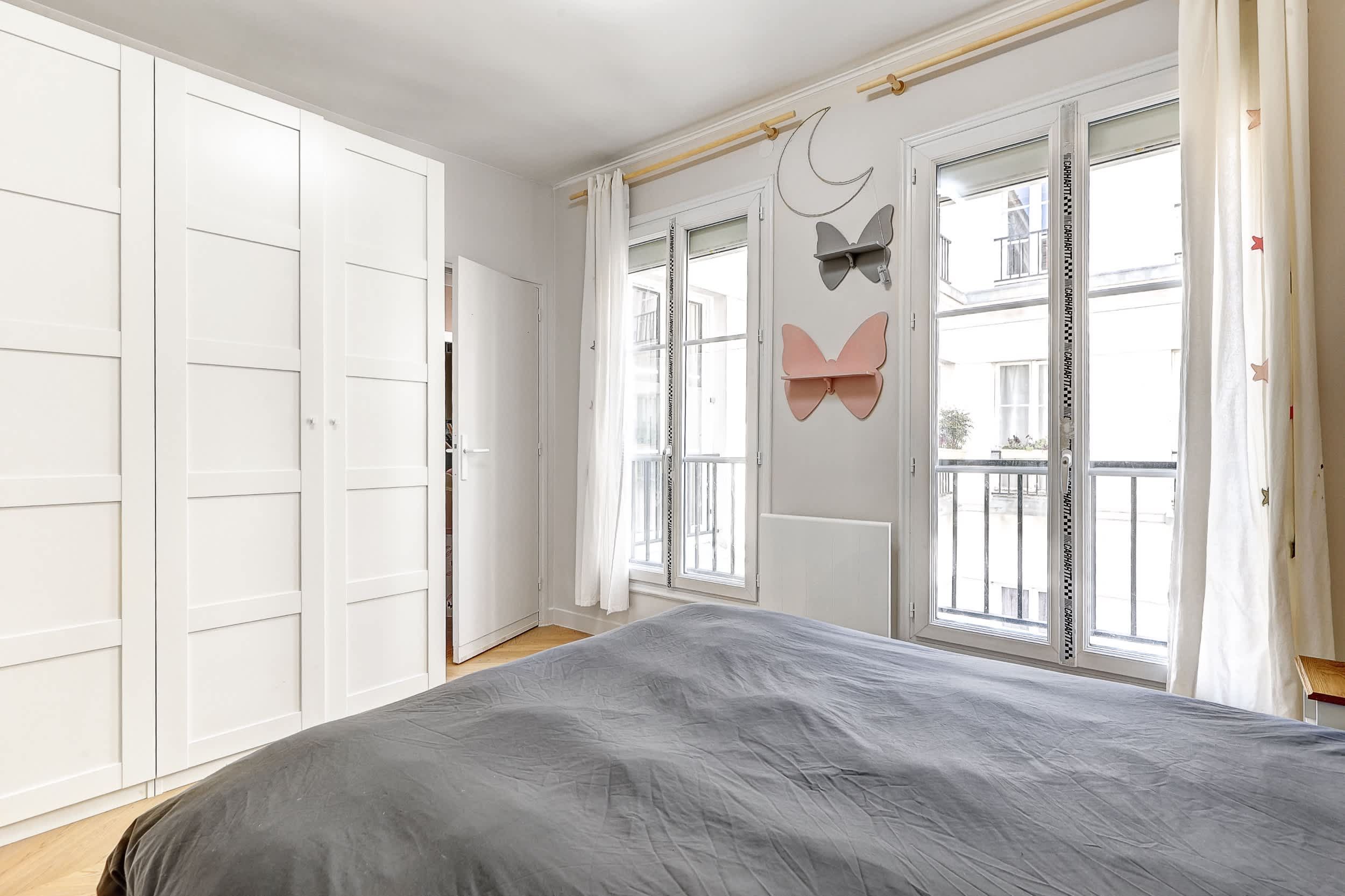Top-floor Haussmann apartment on rue Meslay near République Paris 3rd, bright dual-aspect living room with designer sofa bed and refined decor