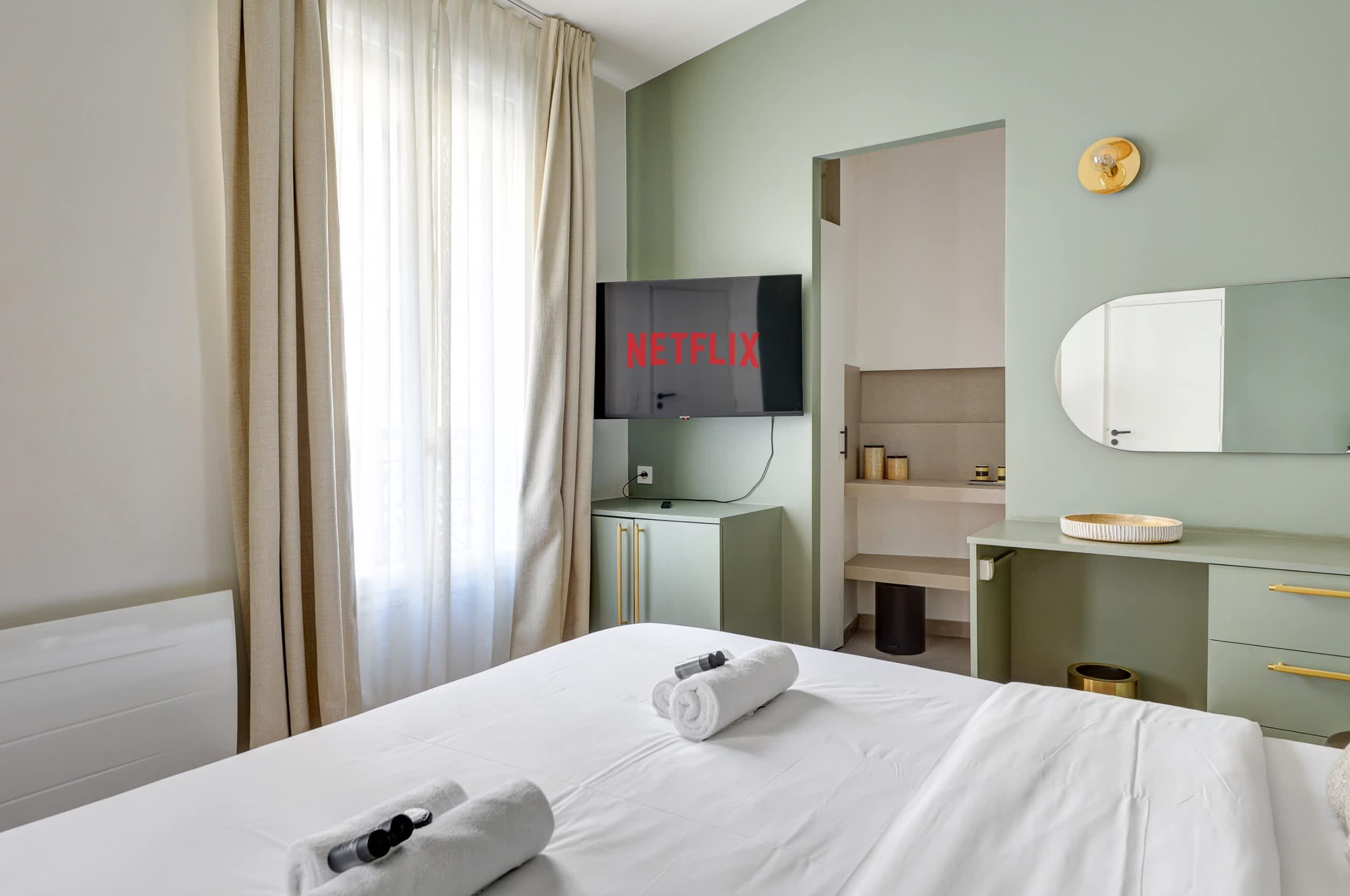 Chambre : lit double, bureau avec rangement et miroirs