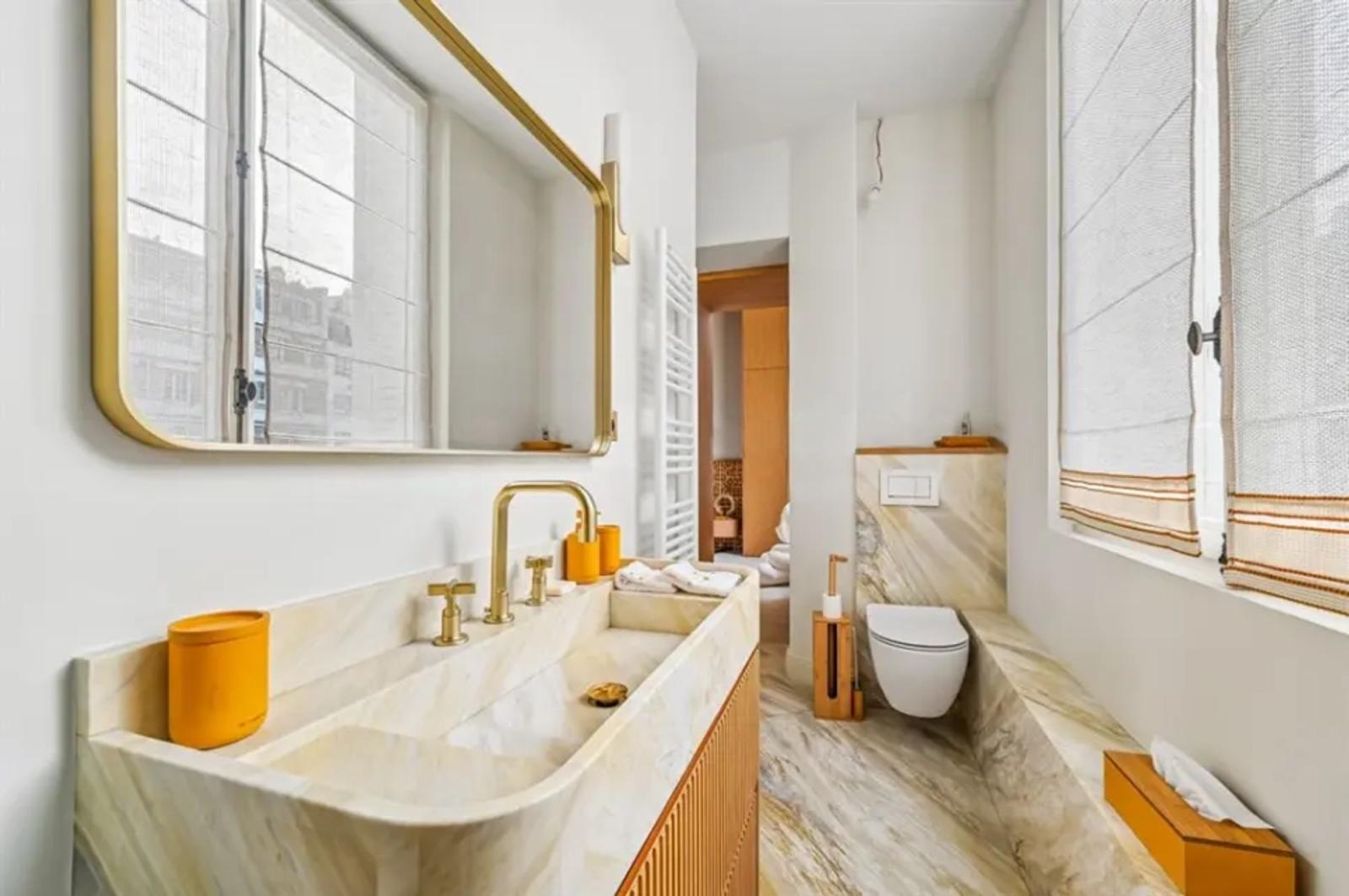 Salle de bains en marbre avec robinetterie dorée