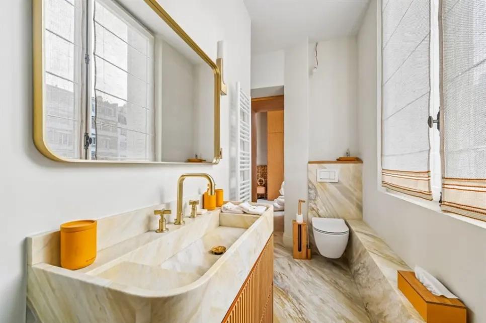 Salle de bains en marbre avec robinetterie dorée