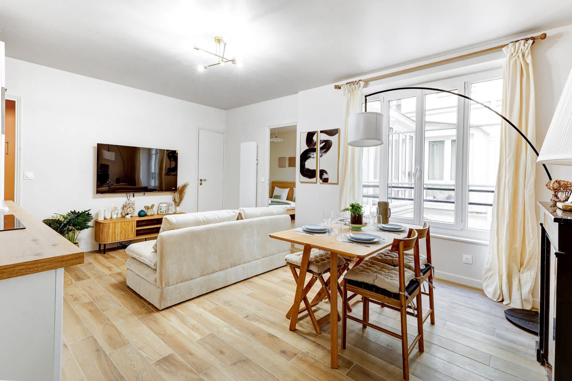 Appartement meublé rénové de 55 m² rue des Tournelles Paris 4e, canapé-lit et coin repas dans un intérieur lumineux du Marais