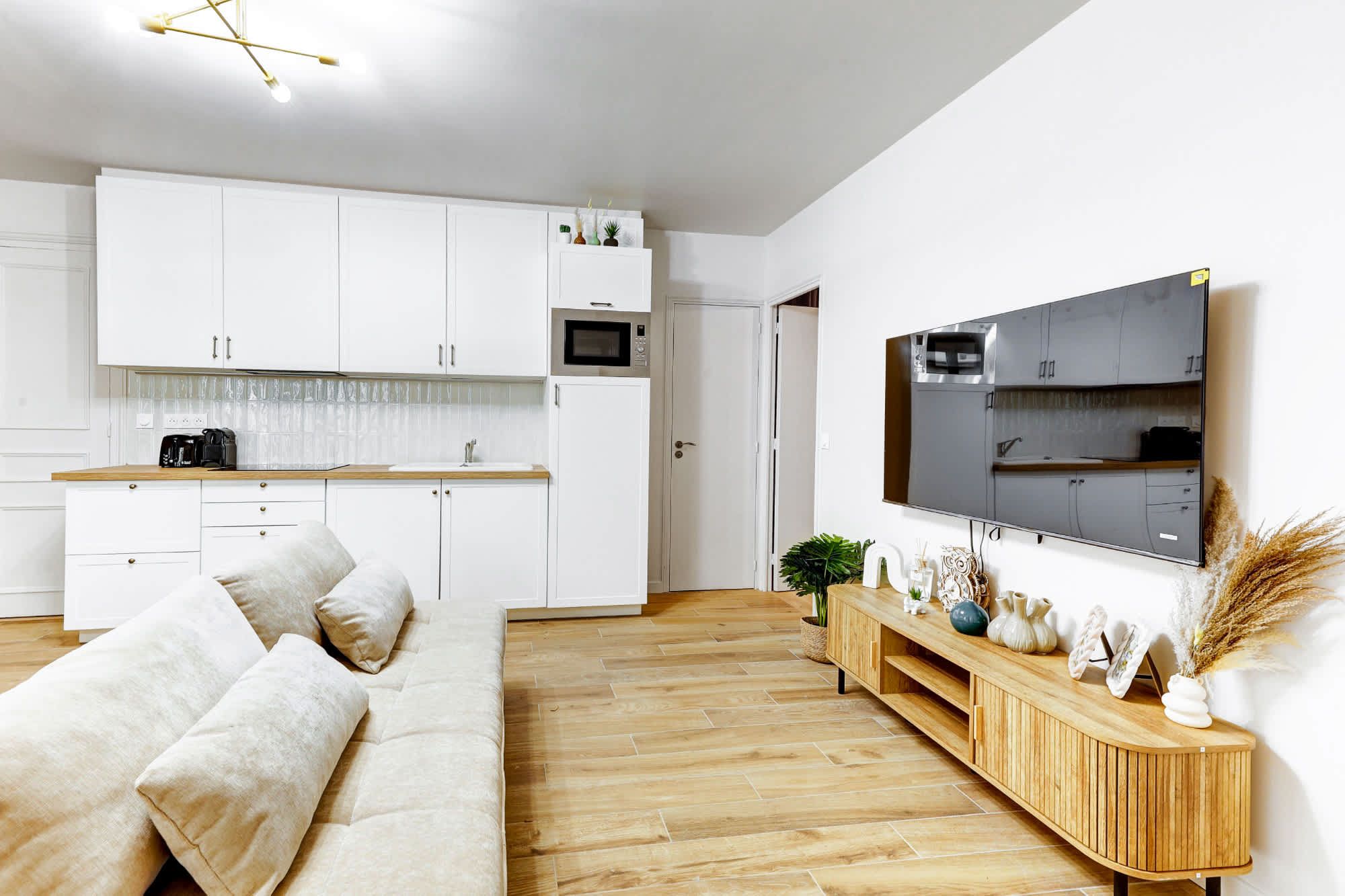 Appartement meublé rénové de 55 m² rue des Tournelles Paris 4e, canapé-lit et coin repas dans un intérieur lumineux du Marais