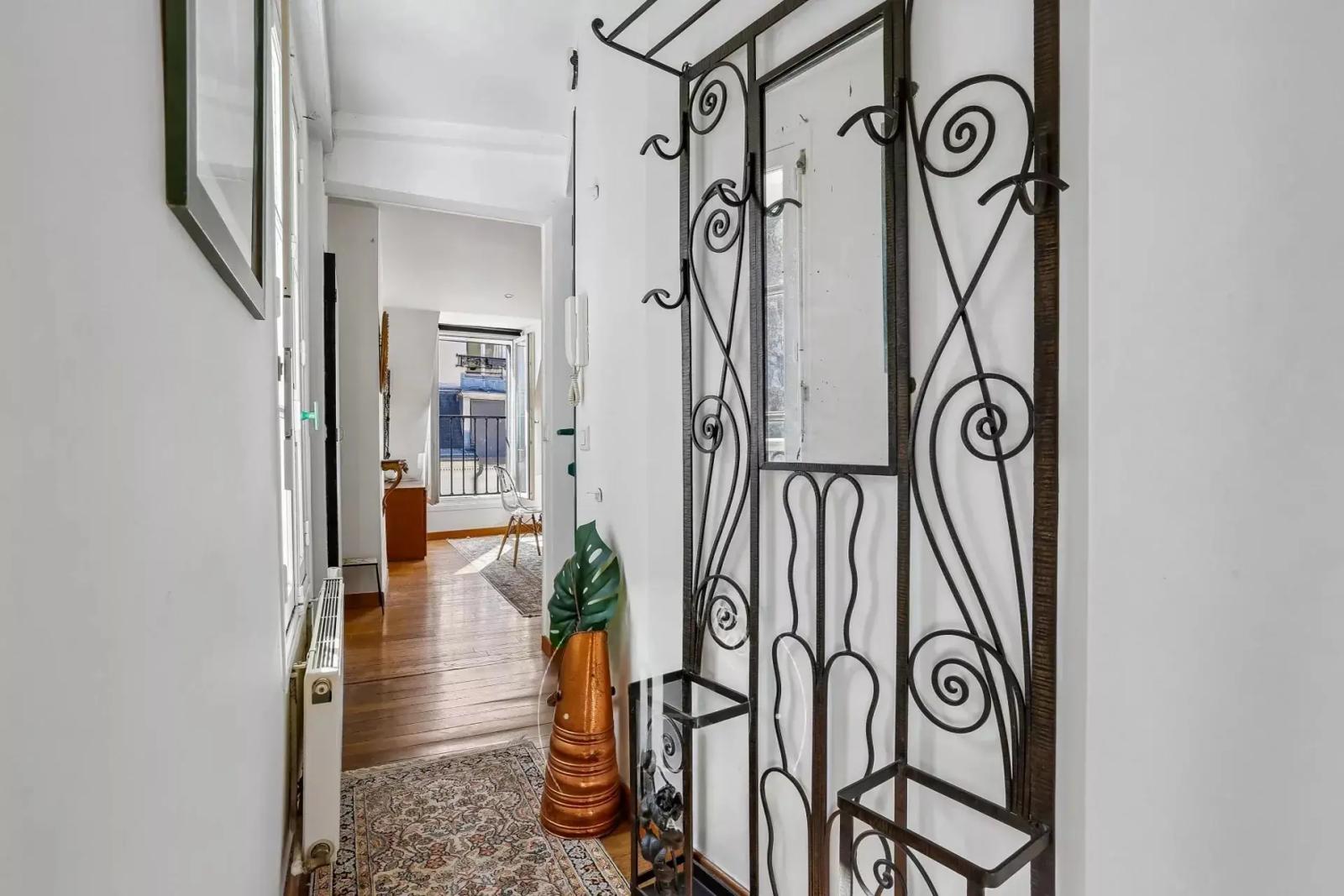 Entrée avec miroir en ferronnerie et parquet