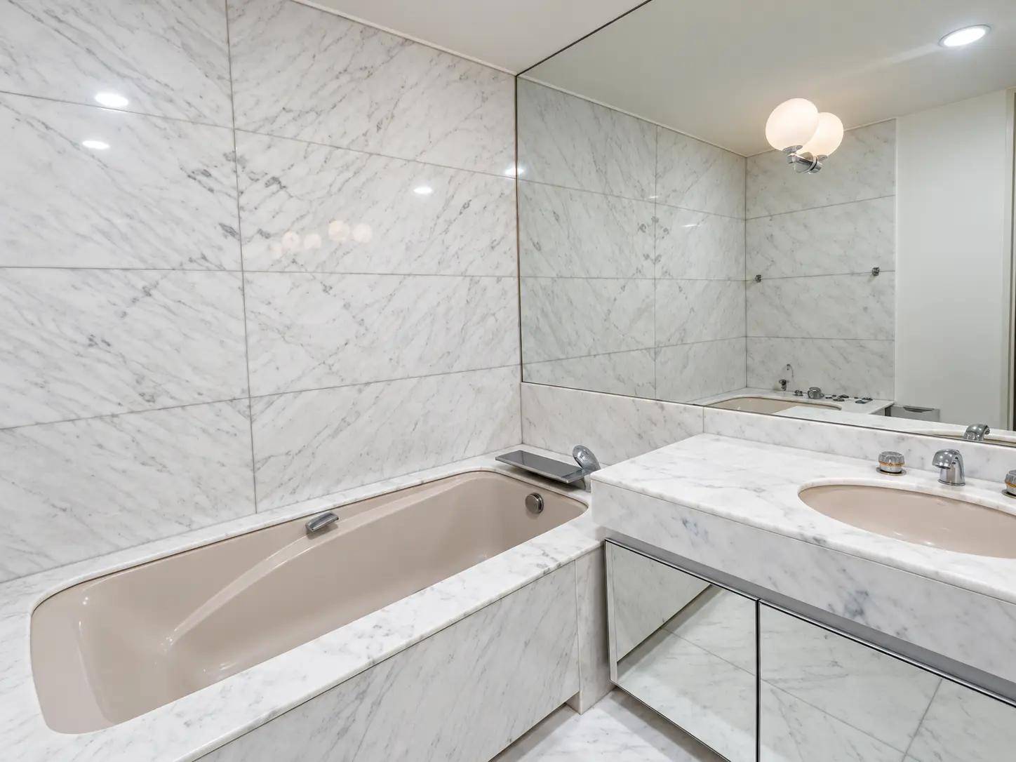 Marble bathroom with bathtub and vanity in Neuilly apartment