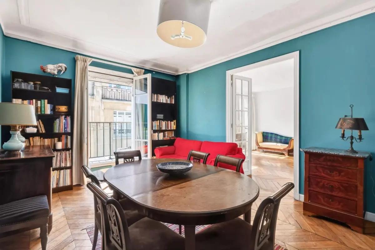 Salle à manger avec bibliothèque et canapé rouge