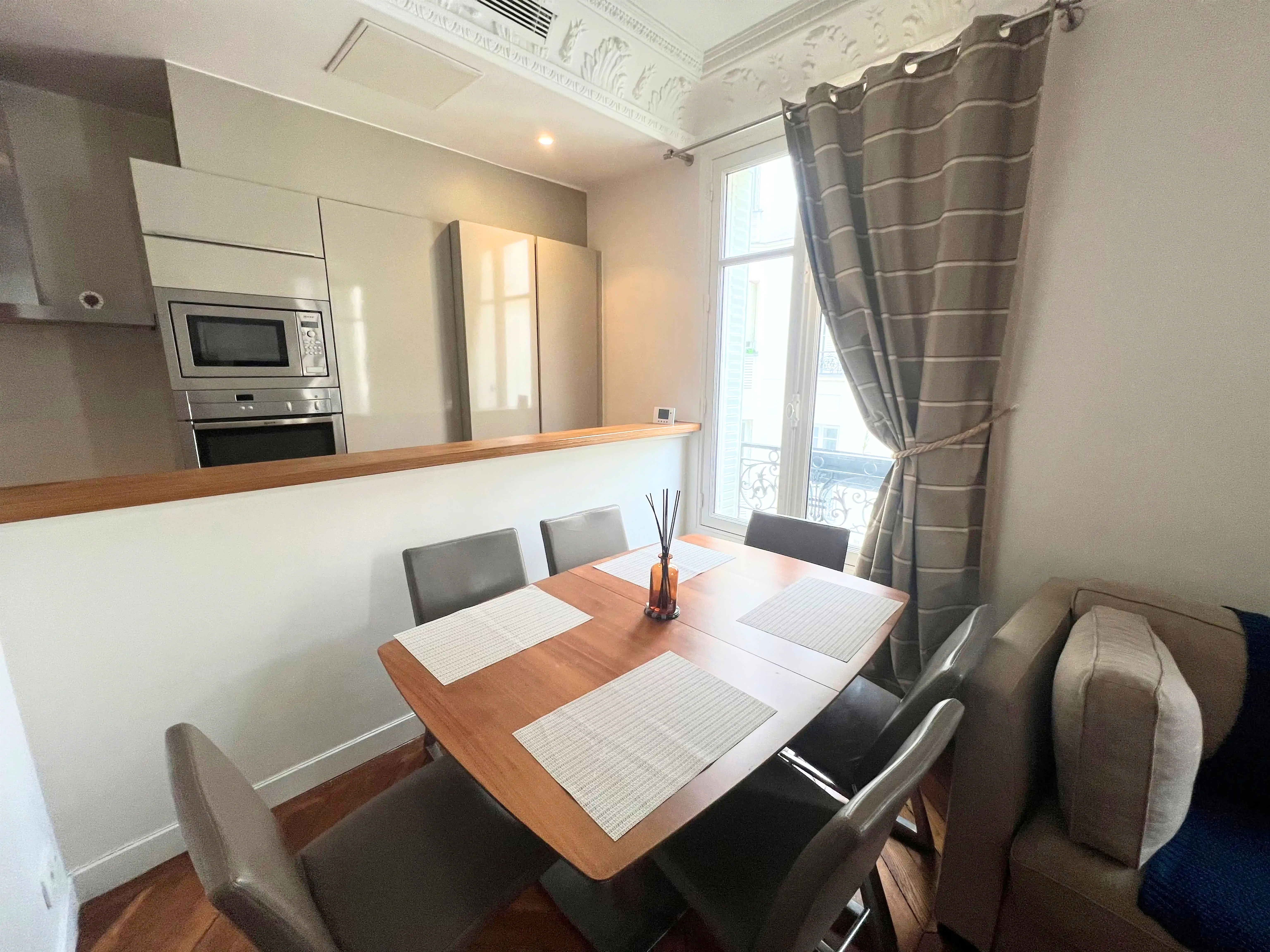 Elegant 2-bedroom apartment for rent rue Saint-Didier Chaillot Paris 16e, bright living room with mouldings, point de Hongrie parquet and semi-open kitchen