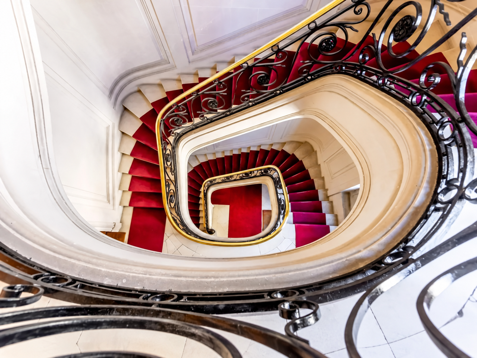 Escalier sculpté avec tapis rouge à Paris 7e