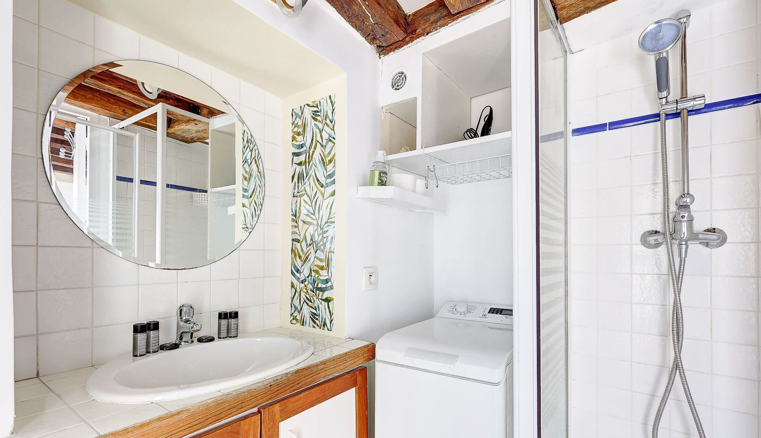 Bathroom: shower, washing machine, sink, mirror, storage, and toilet.