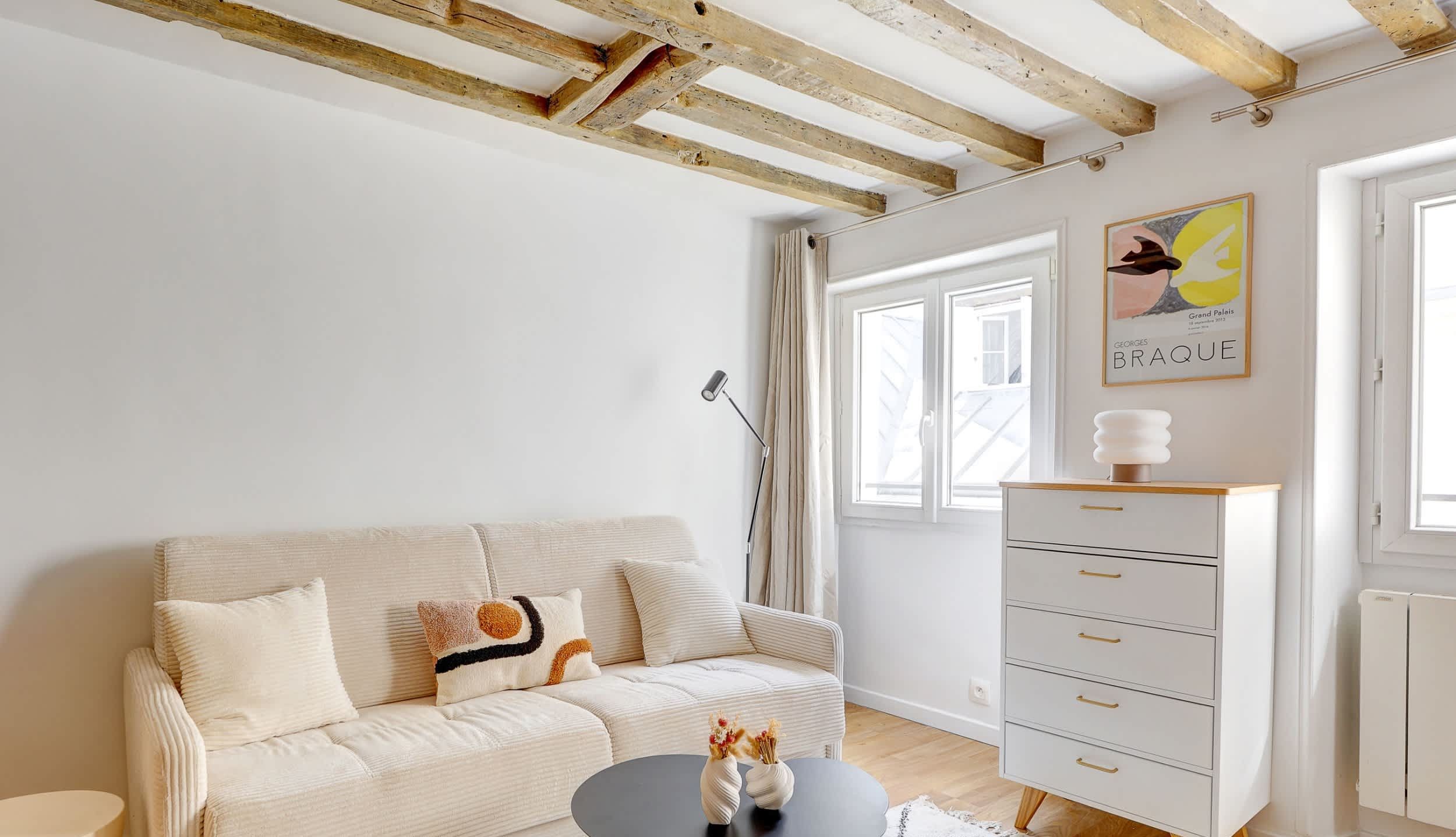 Welcome to our living room, open onto the kitchen, featuring a comfortable sofa bed, a dining corner and a TV.