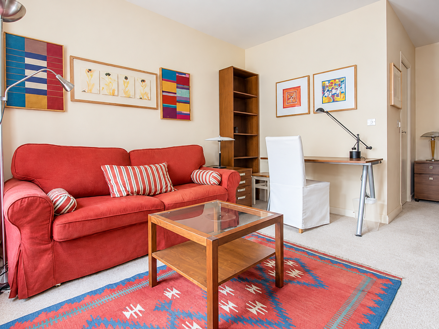 Furnished living area with red sofa, desk and built-in storage