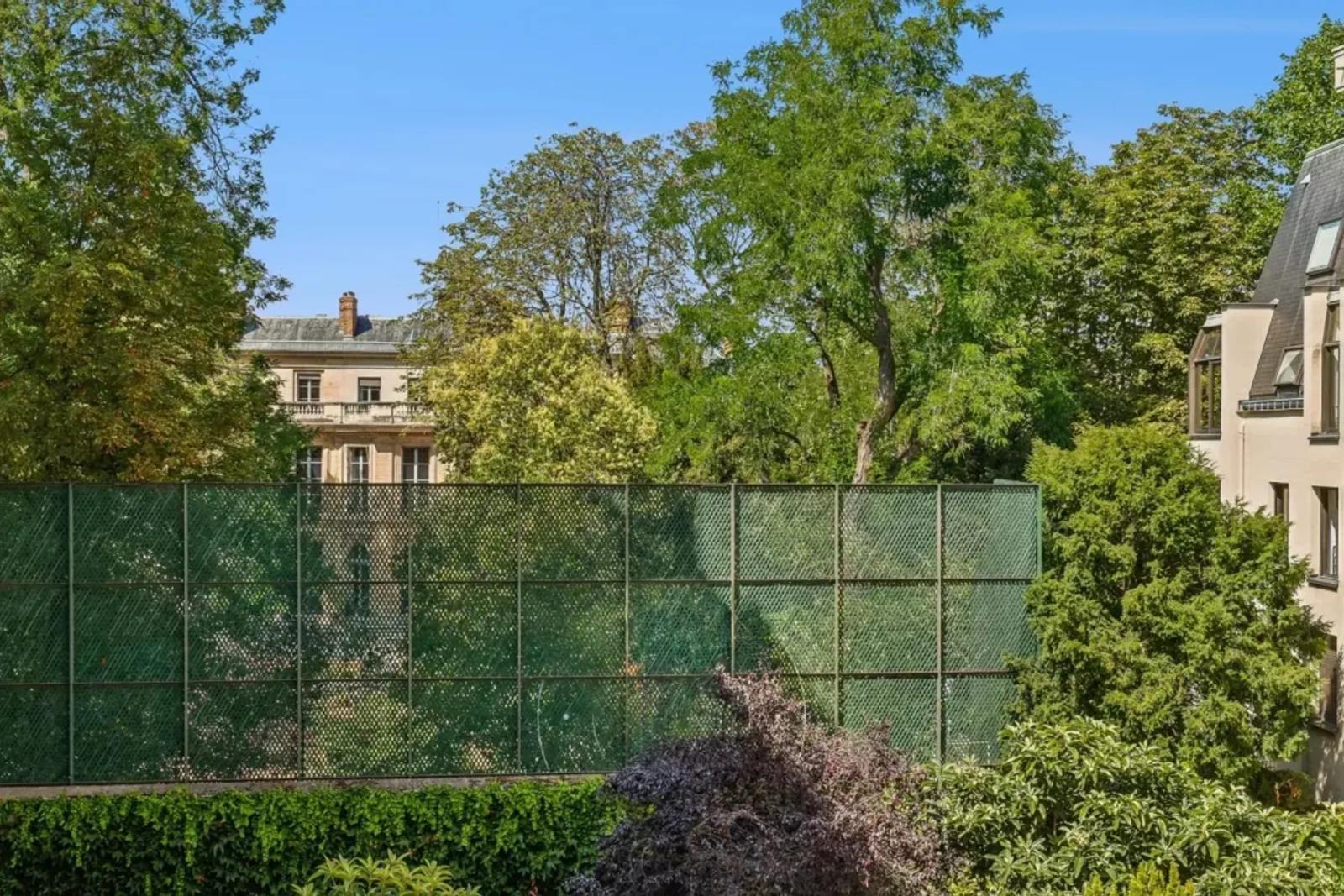 Vue sur cour arborée depuis un appartement parisien