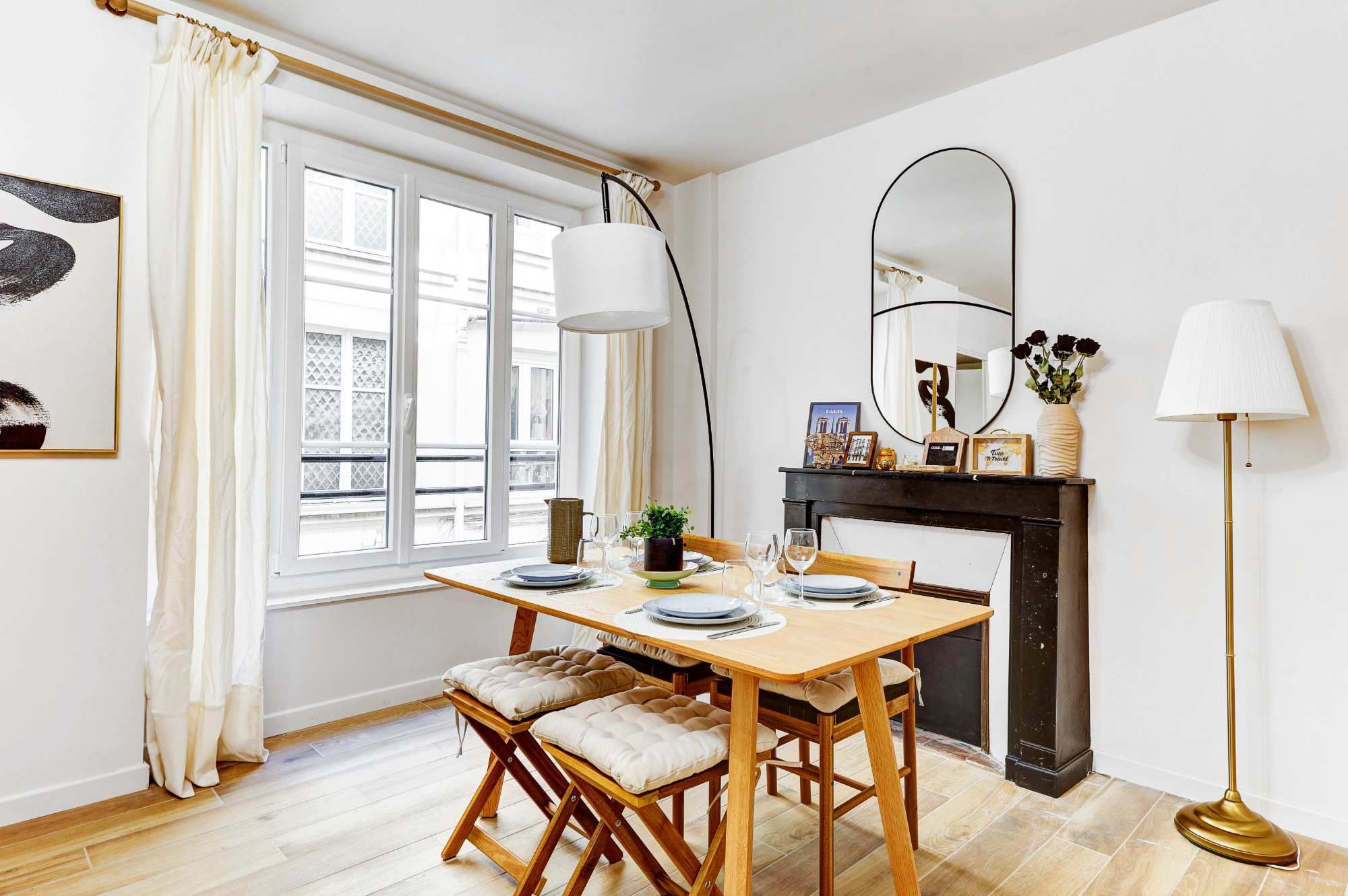 Appartement meublé rénové de 55 m² rue des Tournelles Paris 4e, canapé-lit et coin repas dans un intérieur lumineux du Marais