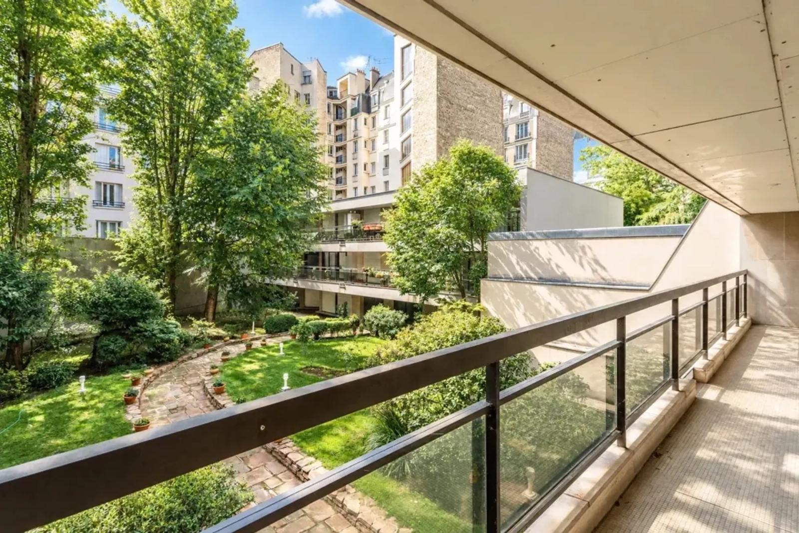 Long balcon couvert avec vue sur jardin paysager