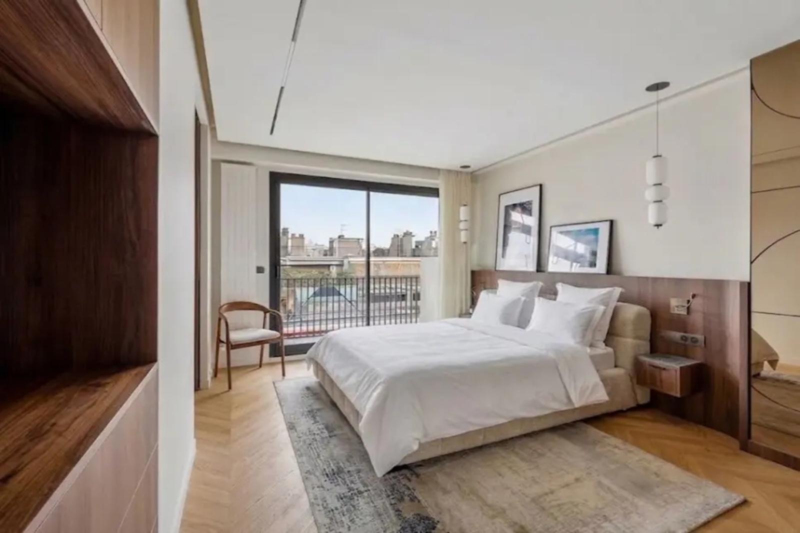 Chambre lumineuse avec accès balcon et tête de lit en bois
