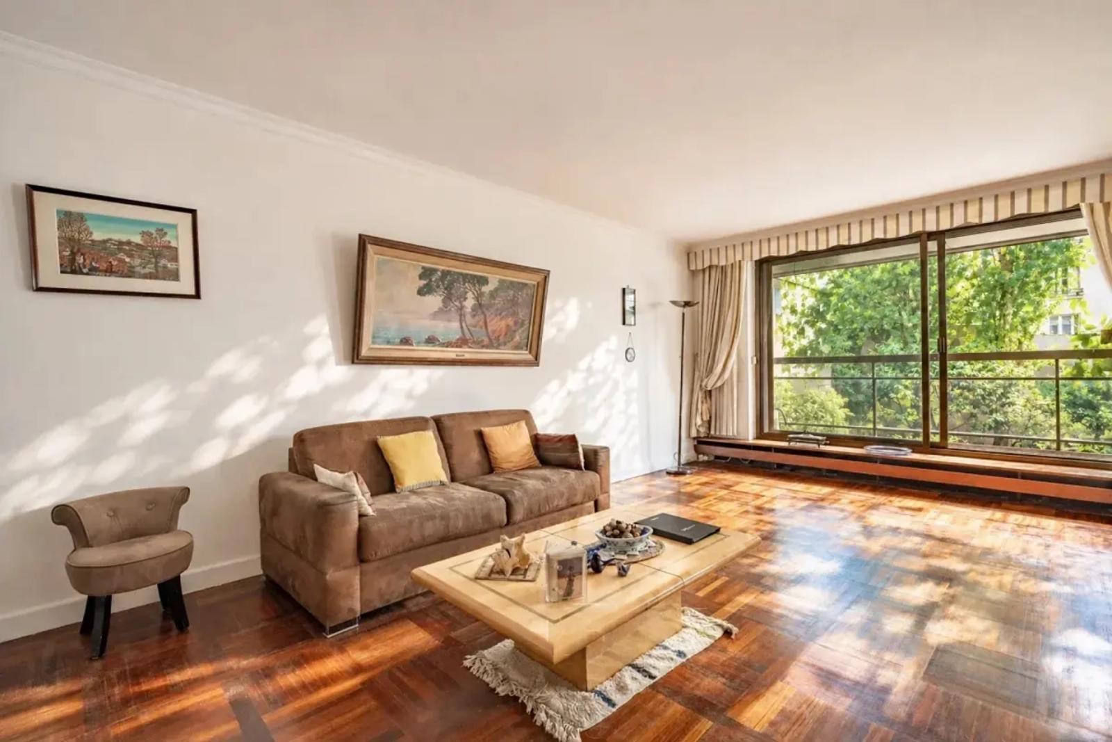 Salon lumineux avec canapé et parquet en bois