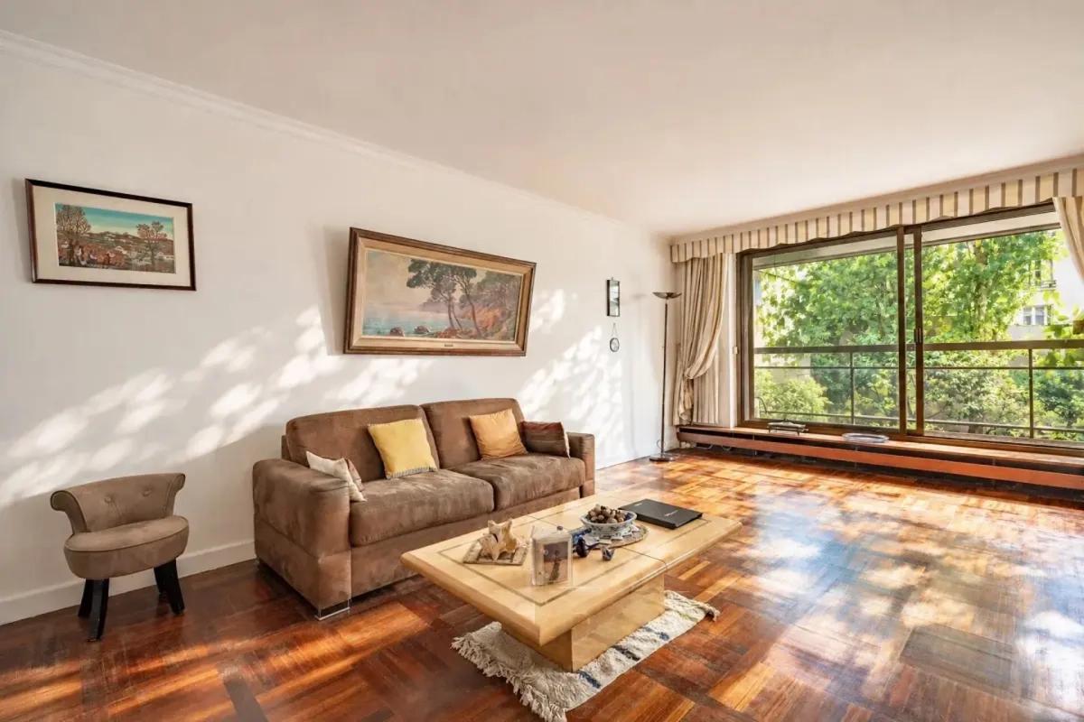 Salon lumineux avec canapé et parquet en bois