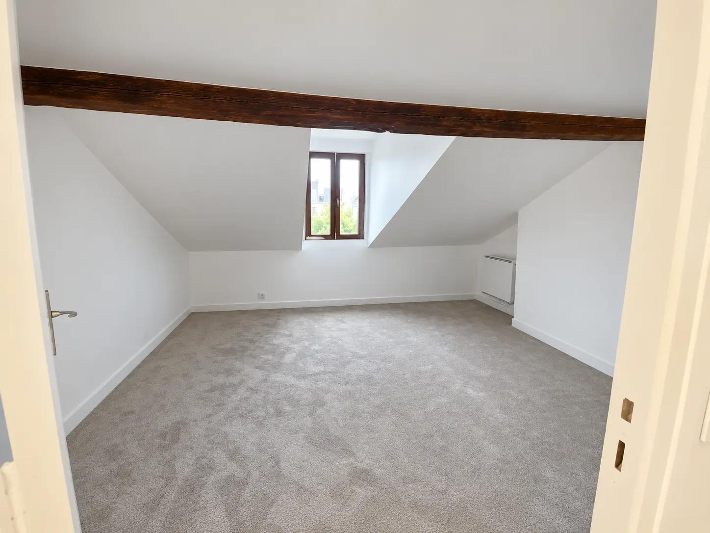 Bright bedroom with exposed beam in top-floor Boulogne apartment