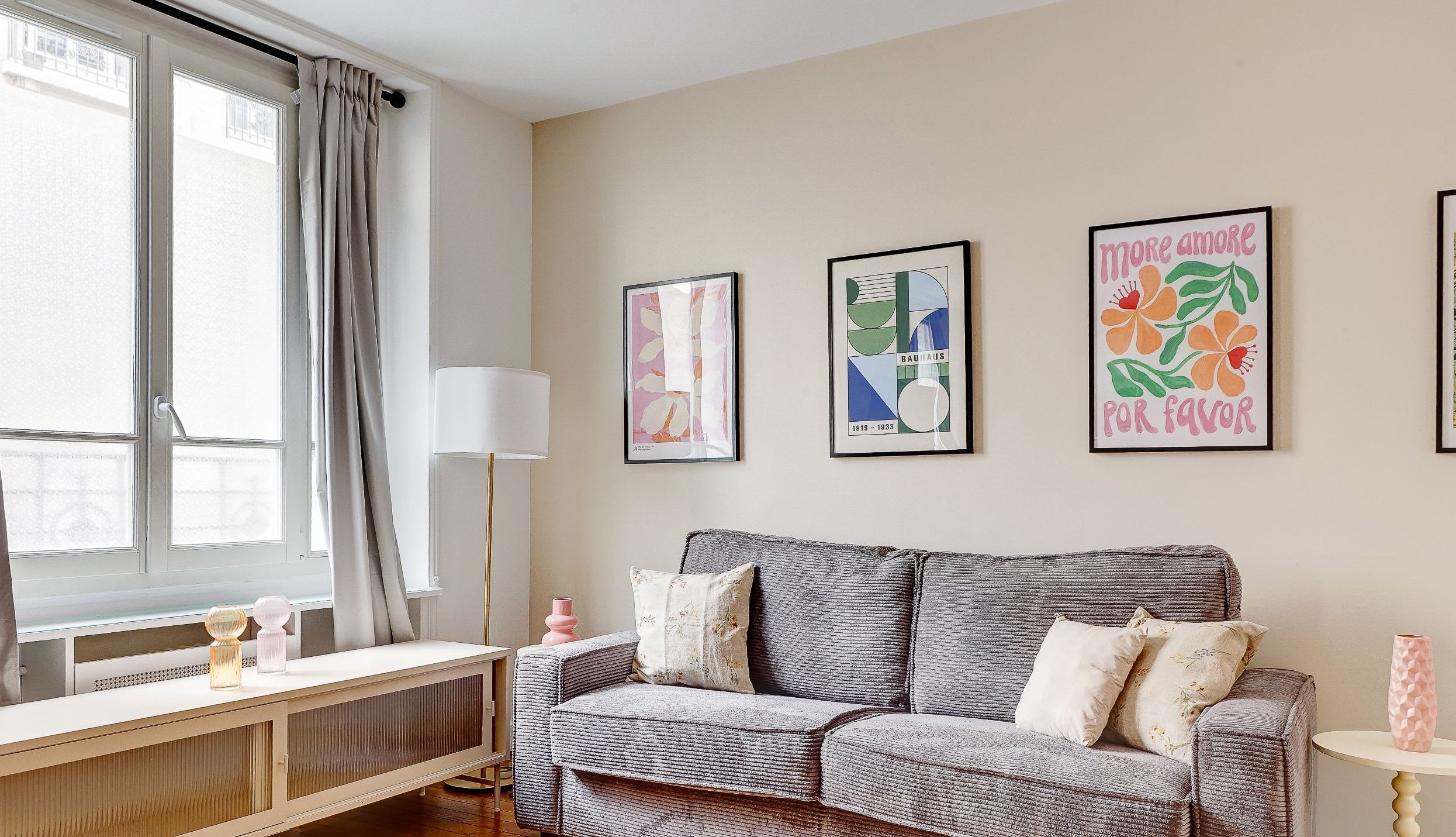 Modern Montparnasse apartment living room with convertible sofa, dining corner, and bright natural light.